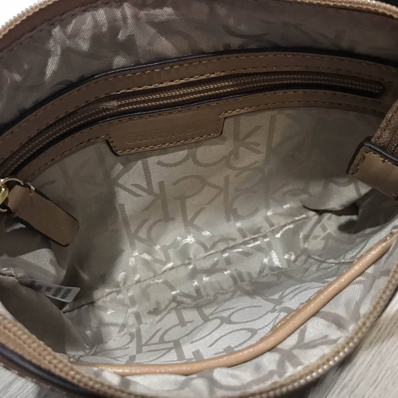 Calvin Klein Cross Body Bag กระเป๋าสะพายรุ่นใหม่ล่าสุดหนังสวย สกรีนลาย Signature แบรนด์รอบใบ ประดับโลโก้แบรนด์ สีทองด้านหน้า เปิดปิดด้วยซิป น้ำหนักเบา ภายใน โล่งกว้าง มีช่องใส่บัตร และช่องซิป ใส่ iphone+ ได้ มาพร้อมสายสะพายยาว ขนาดกำลังน่ารัก สะพายคล่องตั