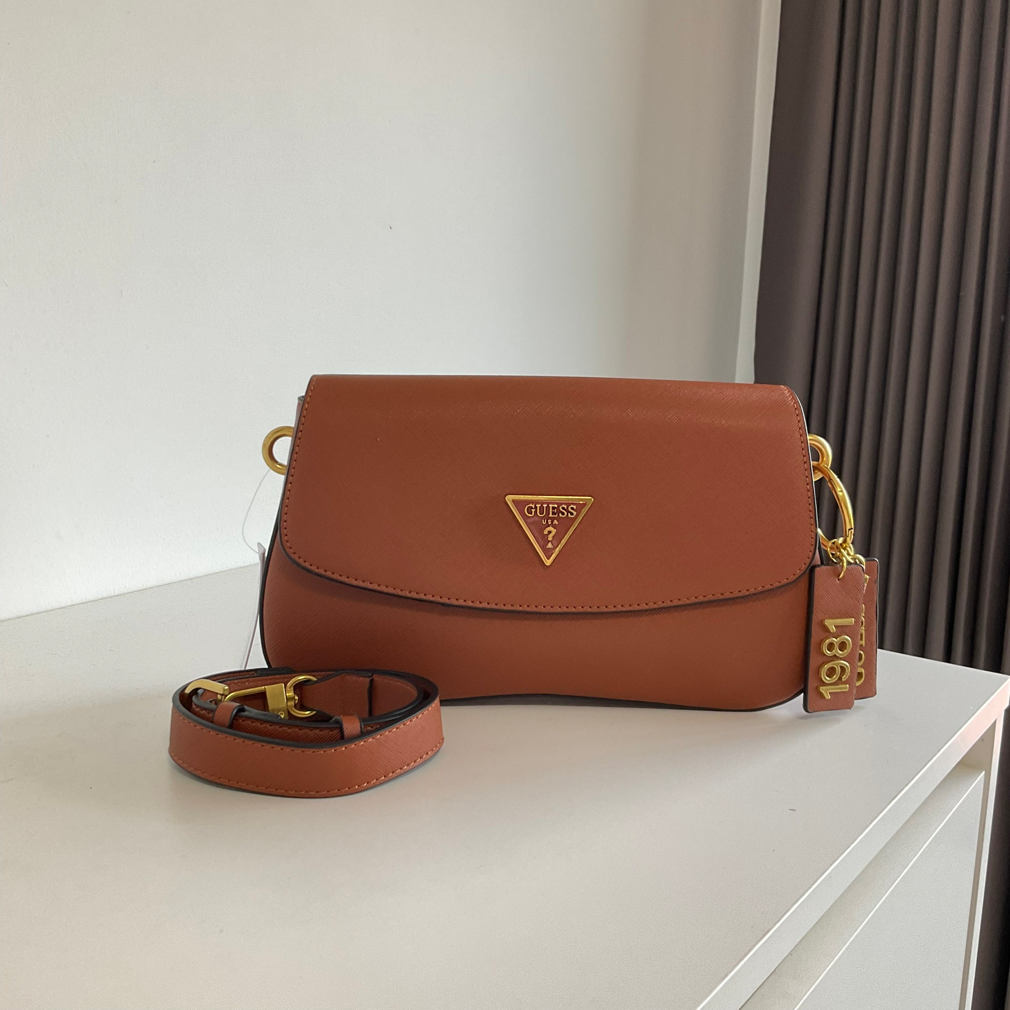 GUESS COLDELIA LOGO FLAP BAG กระเป๋าสะพายไหล่ หนังสวยหรู พิมพ์ลาย อะไหล่ทอง เปิดปิดด้วยกระดุมแม่เหล็ก มีช่องเล็กด้านหน้าหนึ่งช่อง ด้านในใส่กระเป๋าสตางค์ยาว มือถือได้ทุกรุ่น พร้อมช่องซิปแยกให้ มาพร้อมสายสะพายไหล่ปรับและถอดได้ ไอเท็มล่าสุดใบนี้ต้องมีนะคะ