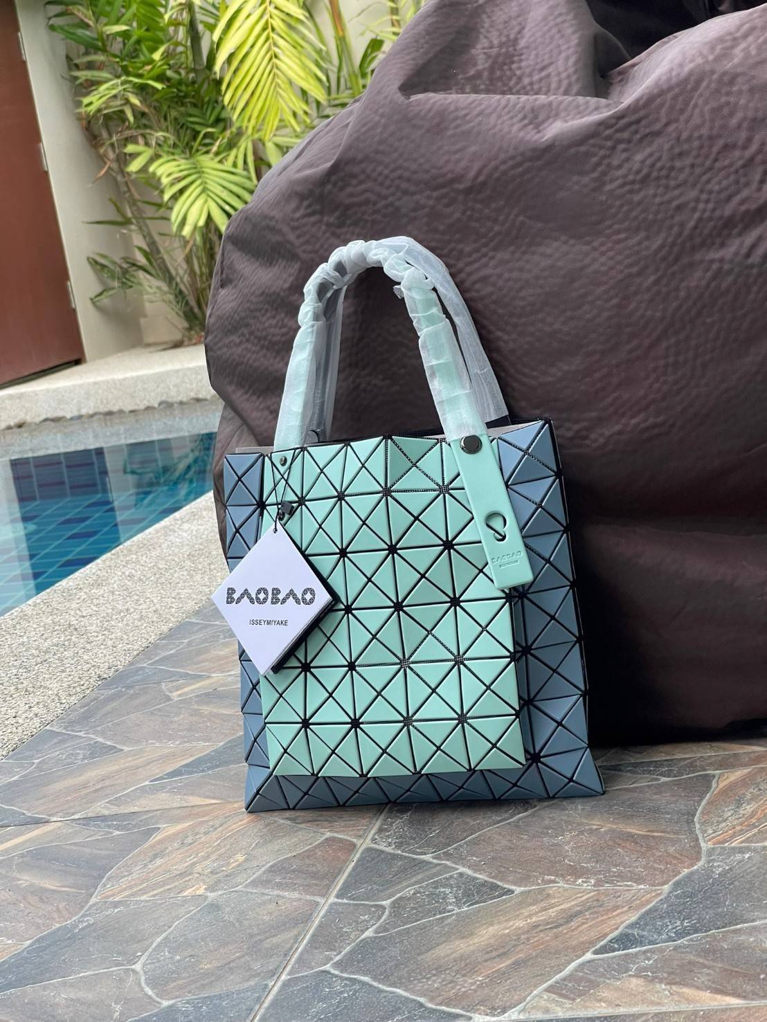 Baobao Issey Miyake Prism Kangaroo tote bag กระเป๋าถือทรงโท้ทที่ประดิษฐ์ขึ้นอย่างเชี่ยวชาญในญี่ปุ่น มาพร้อมแผงเรขาคณิตสำหรับการออกแบบที่ได้รับแรงบันดาลใจจากกระดาษพับ ซิลลูเอทอันเป็นเอกลักษณ์นี้ปิดท้ายด้วยสายรัดแบบอสมมาตร มีการพัฒนาโครงสร้างทรงสามเหลี่ยมเพ