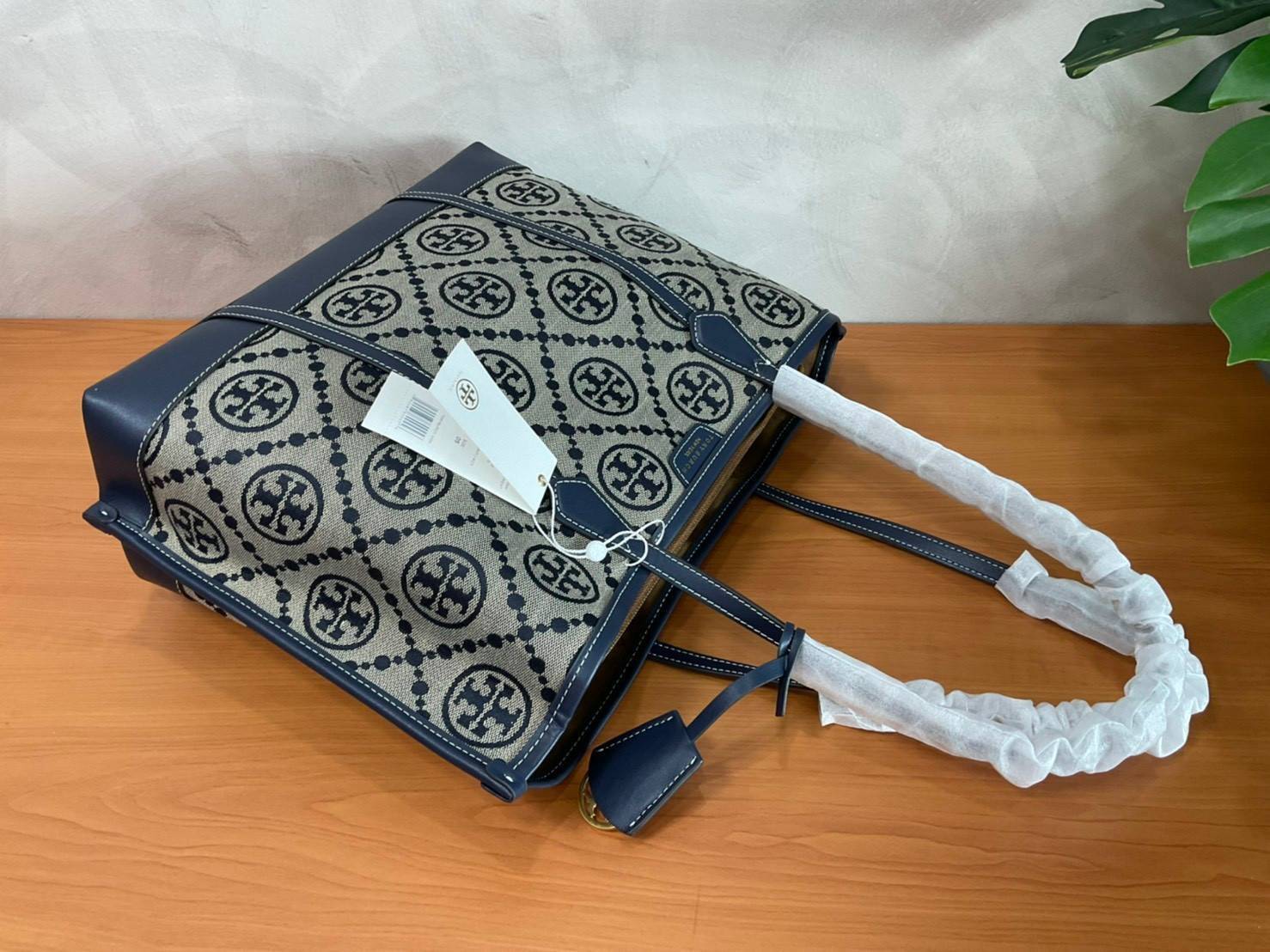 TORY BURCH T MONOGRAM TRIPLE - COMPARTMENT TOTE กระเป๋า/สะพายไหล่ทรง SHOPPING BAG วัสดุผ้าผ้าแคสวาสปักลายสัญลักษณ์แบรนด์ ตั้งอยู่ทรง สวยหรู ดูแพง จุของได้เยอะมาก ภายในแยกเป็น 2 ช่องหลัก 1 ช่องซิปตรงกลาง แบ่งเป็นสัดส่วนใช้งาน