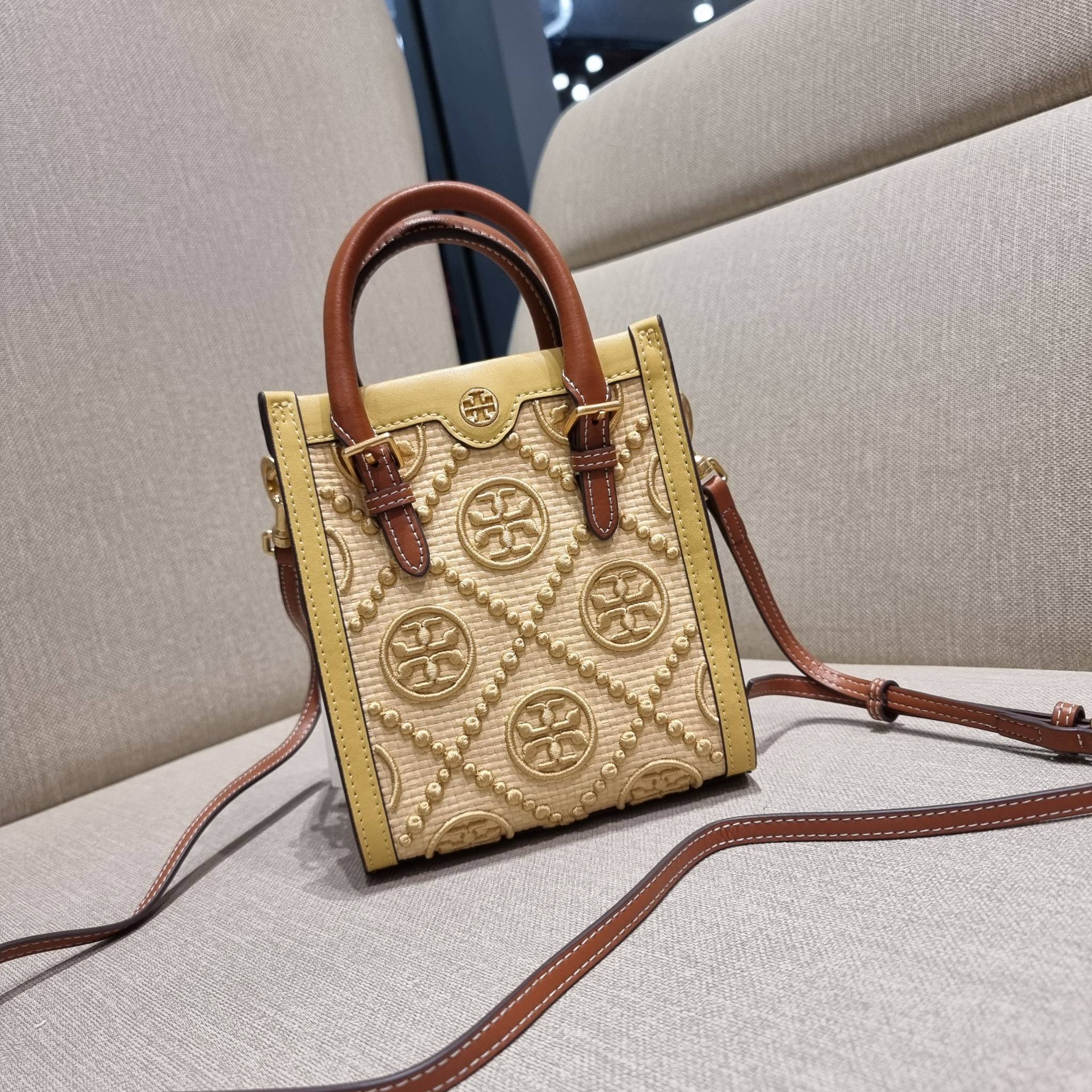 TORY BURCH T MONOGRAM STRAW MINI TOTE สวยสุด ดูแพงสุด!! ต้องยกให้เลย กับไอเท็มนี้ กระเป๋าสะพายทรงโท้ท ไซส์มินิ มีลูกเล่นที่ดีเทลเยอะมาก ด้วยงานฝีมือปักสานด้วยวัสดุจากกธรรมชาติ ถักทอเป็นลายเส้นขึ้นลายนูน ตัดขอบด้วยหนังแท้ และยังโดดเด่นด้วยหูจับในตัวโทนสีอุ