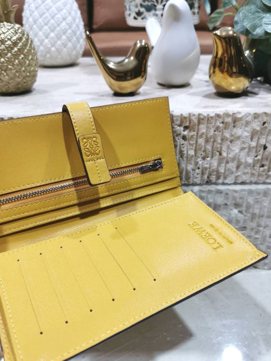 LOEWE LONG WALLET BAG วัสดุหนังแท้เทคเจอร์สวยอยู่ทรงปั้มโลโก้แบรนด์ด้านหน้าเปิดปิดด้วยกระดุม ภายในมีช่องใส่ธนบัตรหลายช่อง ช่องหลักสามารถใส่มือถือได้ มีช่องซิปใส่เหรียญ ช่องใส่ธนบัตรใส่แบงก์พันได้ สวยน่าใช้ พร้อมส่งที่ไทยสุดคุ้มห้ามพลาด!
