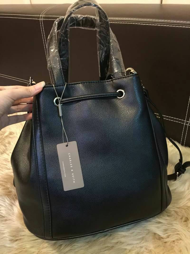 CHARLES & KEITH TASSEL DRAWSTRING BAG กระเป๋าถือหรือสะพายหนังนิ่มสวย น้ำหนักเบา ดีไซน์โดดเด่น ที่หูรูด Drawstring ประดับพู่ สามารถถือหรือสะพายได้ 2 ทรง ไม่จำเจ ปั๊มโลโก้ด้านหน้า ภายในมีช่องซิปเเละช่องเล็กใส่ของ ฐานเสริมอย่างดีใส่ ipad / iphone ของใช้ได้จุ