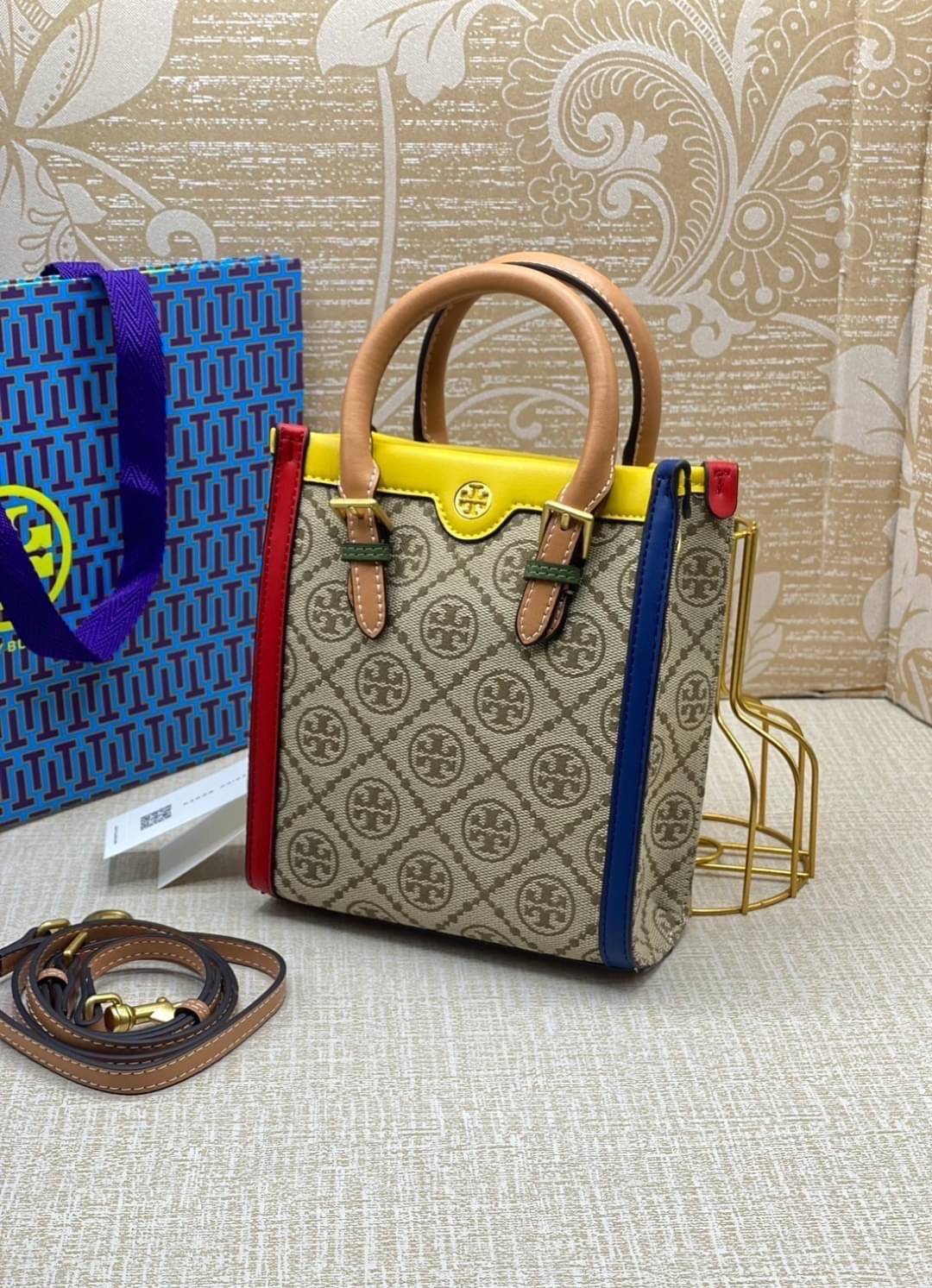 TORY BURCH T MONOGRAM COLORBlOCK JACQUARD MINI TOTE คอลเลคชั่นใหม่ล่าสุด ครอบครองก่อนใคร ไอเท็มยุคนี้รุ่นที่ควรมีติดตู้คะสาวๆ วัสดุ jacquard สลับหนังแท้ หูจับ มาพร้อมสายสะพายข้างหนังแท้ ปรับระดับได้ สายสามารถถอดออกได้ ภายในเป็นช่องโล่ง ใส่มือถือได้ กระเป๋
