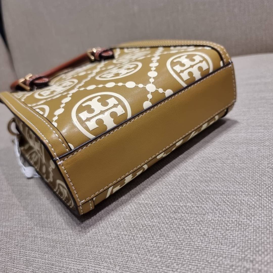 TORY BURCH T MONOGRAM EMBOSSED MINI TOTE สุดหรูกับกระเป๋าสะพายทรงโท้ท ไซส์มินิ ที่สร้างความหรูหราให้ตัวกระเป๋าด้วยดีเทลลายนูน แต่งแต้มลวดลายเอกลักษณ์ สีลูกคุณมากๆ!! วัสดุหนังแท้ ผิวสัมผัสดี ปากกระเป๋ามีแถบแม่เหล็กกันของหล่นได้ ภายในโล่ง ใส่ของจำเป็นได้ โท
