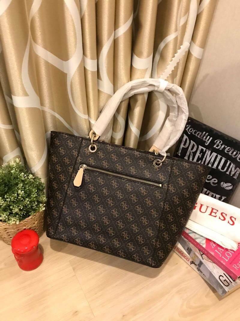 GUESS Kamryn Q Logo Tote สไตล์คลาสสิค ฐานกว้างตั้งอยู่ทรง วัสดุหนังpuลายsignature แบรนด์รอบใบ เปิดปิดด้วยซิปเดียวด้านบน ใช้งานง่าย บุด้วยผ้าสกรียโลโก้ มีช่องเล็กและช่องซิปแยกใช้งานเป็นสัดส่วน ประดับtagโลหะหุ้มหนังเป็นดีเทล ใบใหญ่ใส่นิตยสาร และของใช้ประจำว