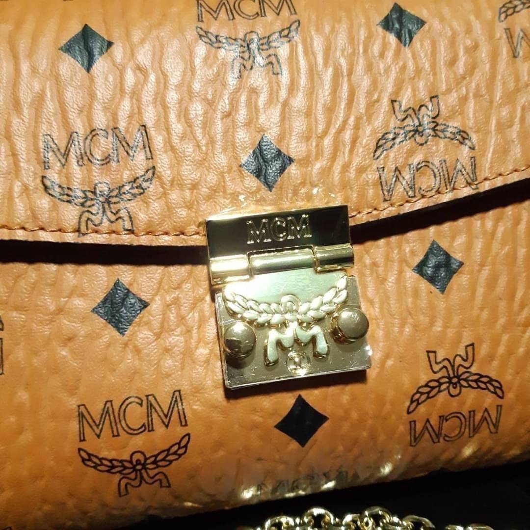 M.C.M MEDIUM MILLIE FLAP CROSSBODY IN VISETOS ฮอตที่สุดอีกหนึ่ง กระเป๋าสะพายกึ่งคลัทช์ มาพร้อมสายสะพายโซ่สีทองหรูหรา รูปทรงดีไซน์ร่วมสมัย ใช้งานง่ายด้วยตัวล็อค วัสดุภายนอกเป็นหนังแคนวาสคุณภาพดี ภายในเป็นหนังแท้สลับผ้า มีช่องซิปแยกอย่างดี ขนาดใบนี้กำลังดีม