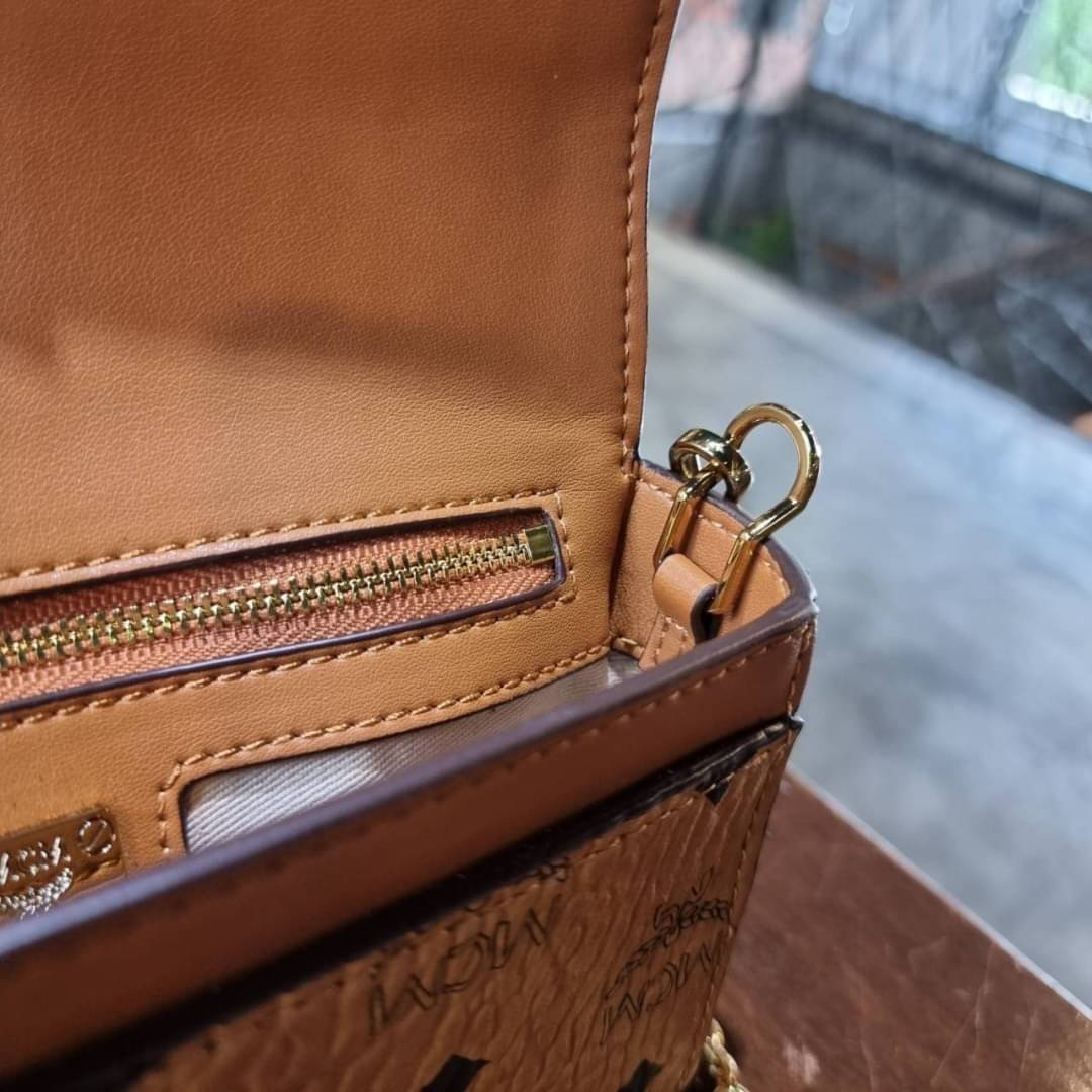 M.C.M SMALL MILLIE FLAP CROSSBODY IN VISETOS ไซส์ใหม่พกพาสะดวก!! กระเป๋าสะพายกึ่งคลัทช์ รอบนี้มาไซส์สวย สามารถใช้แทนกระเป๋าสตางค์ได้เลย ใส่โทรศัพท์มือถือได้ทุกรุ่น ใส่ของสำคัญสบายๆ มาพร้อมสายสะพายโซ่สีทองหรูหรา รูปทรงดีไซน์ร่วมสมัย ใช้งานง่ายด้วยตัวล็อค ว