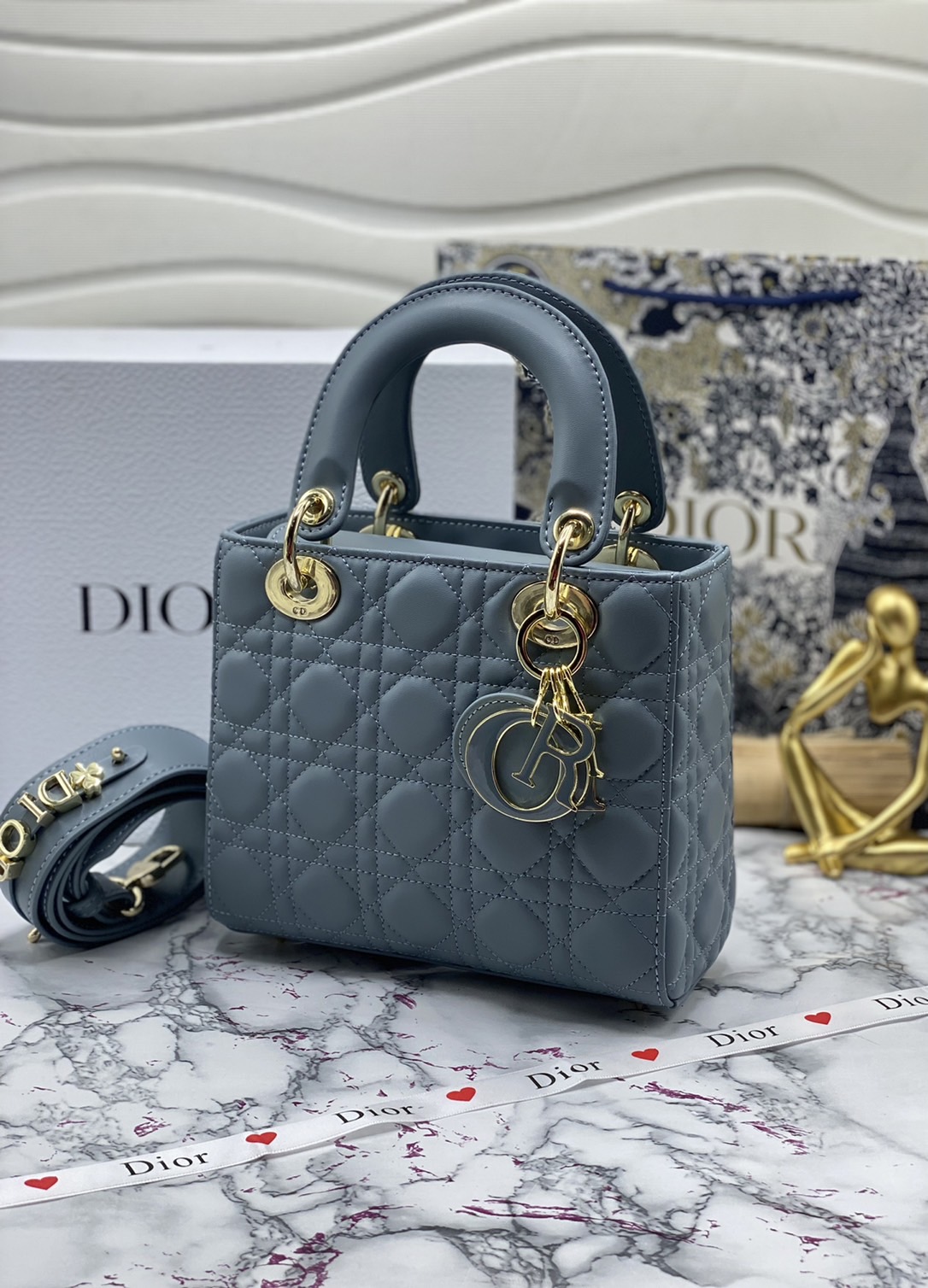 หนังแท้ DIOR LADY BAG 20cm ความสง่างามอีกหนึ่งรุ่นของ Dior รูปทรงสีเหลียม ขนาดกระทัดรัด ตั้งอยู่ทรง ฐานกระเป๋าแข็งแรง มีหมุดรองฐาน ดีไซน์ที่มีเอกลักษณ์เฉพาะตัว ด้านหน้าตกแต่งด้วยตัวอักษร D.I.R ห้อยเป็นพวงกุญแจ จะถือด้วยมือหรือสะพายไหล่ก็ดูดีมากๆ ค่ะ