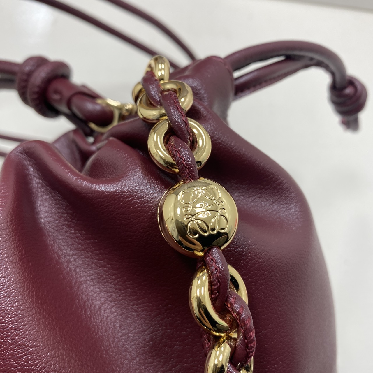 ORI หนังแท้ | LOEWE Mini Flamenco purse in mellow nappa leather / Loewe Bucket Bag กระเป๋าสะพายทรงบัคเก็ตไซส์มินิ หนังเรียบสวยหรู เรียบง่าย หนังแท้ผิวสัมผัสนุ่มมือ น้ำหนักเบาและนุ่มสบาย ดีไซน์จับจีบ เชือกผูกแบบปมโบราณ และสายโซ่รูปโดนัท