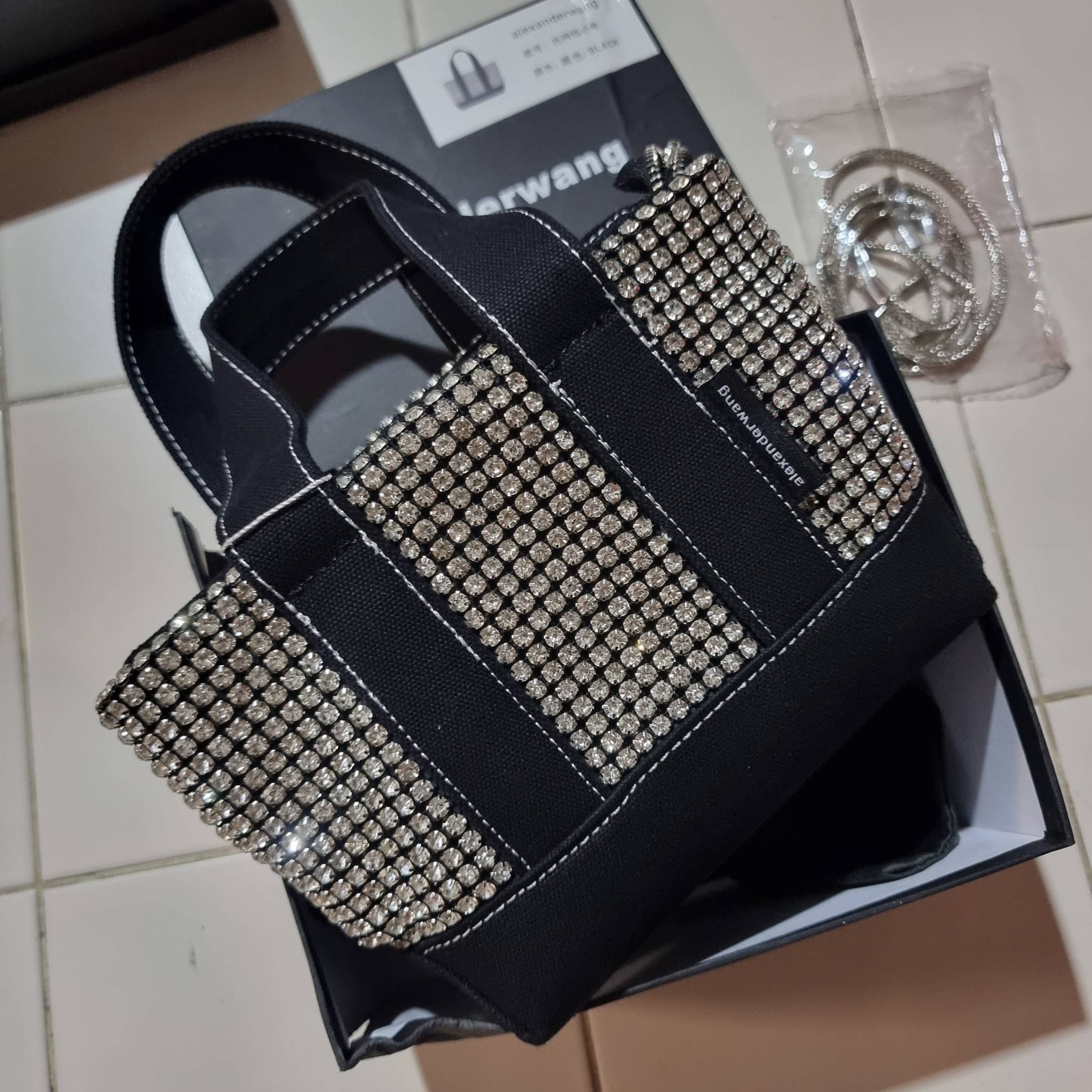 ALEXANDER WANG HANDBAG MINI TOTE WITH RHINESTONE กระเป๋าทรงมินิโท้ท น่ารักน่าเอ็นดู น่าใช้เหลือเกิน!! ด้วยความโดดเด่นเด่นของการตกแต่งพลอยเทียม ให้ดีเทลหรู ตัดสลับด้วยผ้าแคนวาส เพิ่มความทนทาน ลงตัวมากๆ และยังใช้งานง่ายด้วยหูจับในตัว เปิด-ปิดด้วยซิป ภายในเป