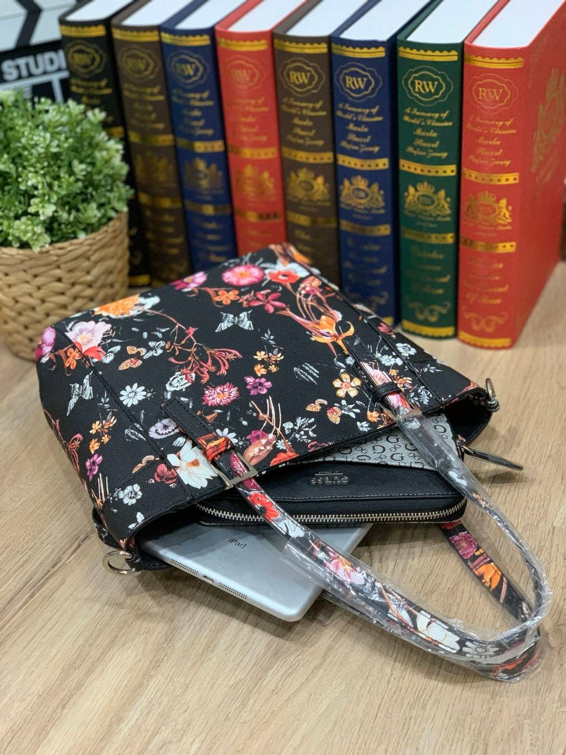 GUESS Women's Medium Floral Tote Bag กระเป๋าถือ คล้องไหล่หรือสะพาย ขนาดกลาง วัสดุหนังpu ลายดอกไม้ชนิดต่างๆรอบใบ เปิดปิดใช้งานด้วยซิปเดียวด้านบน ภายในมีกว้างใส่กระเป๋าสตาวค์ยาว มินิไอแพคได้ หูจับและสายสะพายปรับระดับได้ มาพร้อมกุญแจโลโก้guess สวยน่ารัก