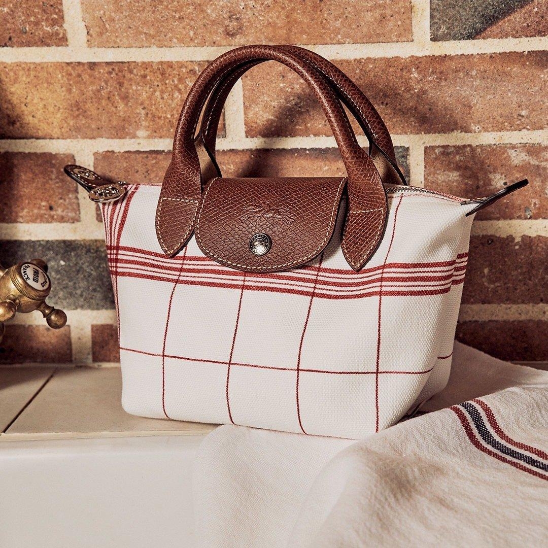 LONGCHAMP LE PLIAGE TORCHON Top handle bag - Red กระเป๋าถือขนาดเล็ก วัสดุผ้าฝ้าย อะไหลเงิน ตัดแต่งด้วยหนังวัวแท้ ผสมผสานแนวคลาสสิกแบบมินิมอลศิลปะการพับกระดาษแบบญี่ปุ่นดั้งเดิม