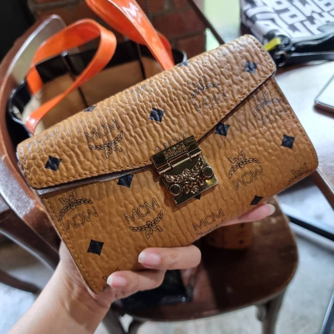 M.C.M SMALL MILLIE FLAP CROSSBODY IN VISETOS ไซส์ใหม่พกพาสะดวก!! กระเป๋าสะพายกึ่งคลัทช์ รอบนี้มาไซส์สวย สามารถใช้แทนกระเป๋าสตางค์ได้เลย ใส่โทรศัพท์มือถือได้ทุกรุ่น ใส่ของสำคัญสบายๆ มาพร้อมสายสะพายโซ่สีทองหรูหรา รูปทรงดีไซน์ร่วมสมัย ใช้งานง่ายด้วยตัวล็อค ว