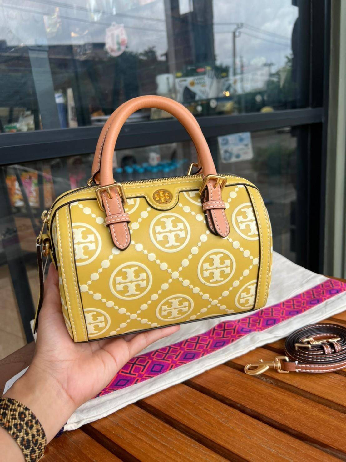 Tory Burch T-Monogram Mini Embossed Wine Bucket Bag / Tory Burch Mini Bucket กระเป๋าถือหรือสะพายไหล่ ทรงหมอนขนาดเล็ก ประดับด้วยลวดลายอันเป็นสัญลักษณ์ของแบรนด์ ถูกประดิษขึ้นด้วยความพิถีพิถันวัสดุหนังอย่างดี ด้านในบุด้วยหนังไมโครซูแอคเนื้อนุ่มทำความสะอาดง่า