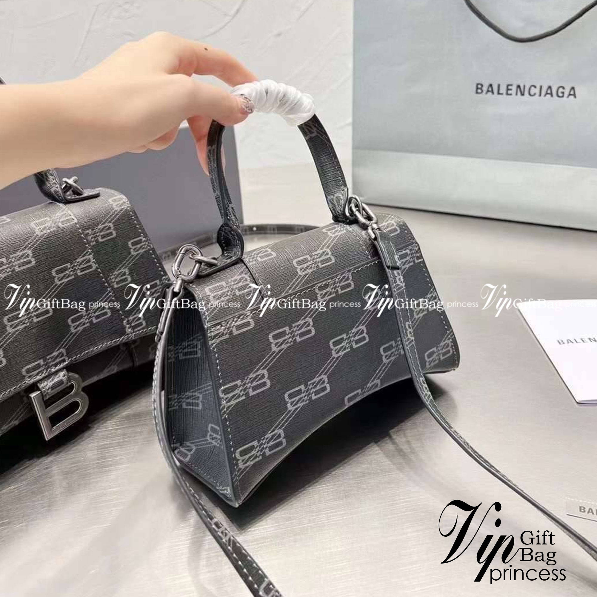 BALENCIAGA Hourglass BB Monogram top-handle tote bag กระเป๋าสะพายแบรนด์หรูซิกเนเจอร์ใบล่าสุด ที่มาพร้อมดีไซน์โดดเด่น มีความโฉบเฉี่ยว โค้งมนเหมือนพระจันทร์เสี้ยว เพิ่มความโดดเด่นสะดุดตาด้วยการตกแต่งอักษร B เมทัลลิก ที่เป็นเอกลักษณ์แบรนด์ งานจริงสวยงามตามรู