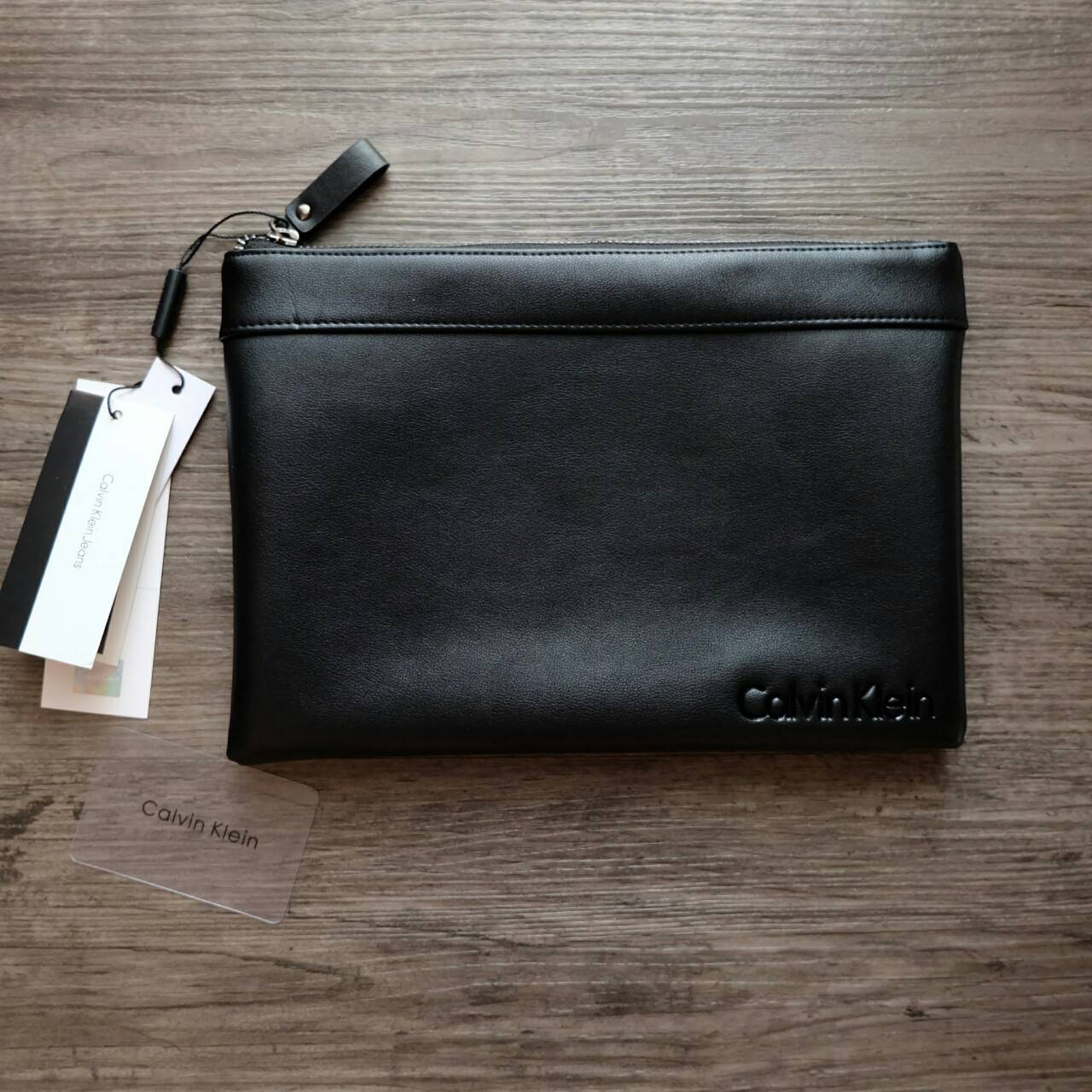 Cluth Bag Calvin Klein Cluth Bag กระเป๋าถือ ทรงคลัทช์ จากแบรนด์ Calvin Klein ด้านหน้า ปั๊มโลโก้แบรนด์ เปิด - ปิดกระเป๋าด้วยซิป ด้านในแบ่งเก็บของ ได้ 2 ช่องใหญ่ และมีช่องใส่บัตร 1 ช่อง สามารถใส่ iPad Mini ได้ค่ะ