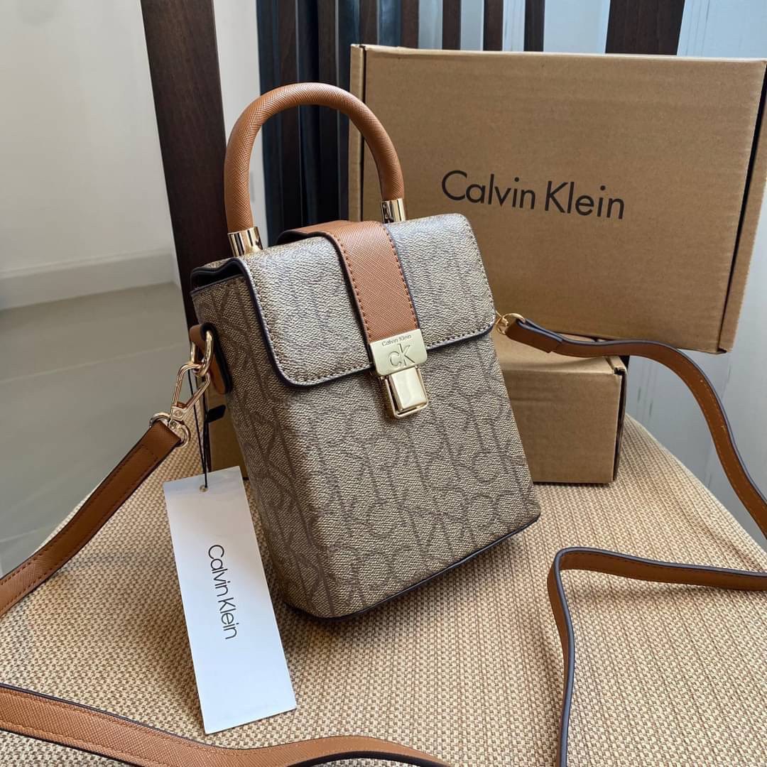 CALVIN KLEIN JEANS crossbody bag กระเป๋าถือหรือสะพาย ลายซิกเนเจอร์แบรนด์ทั้งใบ มีหูจับสำหรับถือ เปิด-ปิดกระเป๋าด้วยกระดุมแม่เหล็ก ด้านในโล่งกว้างมีช่องเล็กและช่องซิปสำหรับใส่ของจุกจิก ซับในลายแบรนด์อย่างดี มาพร้อมสายสะพายยาวปรับระดับได้ สามารถใช้ได้หลากหล