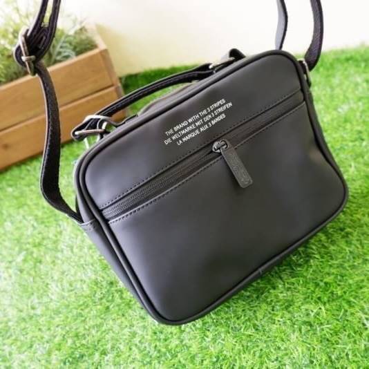 adidas mini airline bag *outlet* กระเป๋าสะพายข้างทรงสปอร์ต ด้านหน้าติดโลโก้แบรนด์ ดีไซน์ลาย 3D ด้านหลังเป็นหนังเรียบ มีช่องซิปสามารถใส่สิ่งของได้ รุ่นนี้เปิดปิดด้วยซิปคู่ ซิปปั๊มแบรนด์ทุกจุด ด้านในเป็นช่องกว้าง มีช่องซิป สายสะพายยาวสามารถปรับระดับได้ สาวก