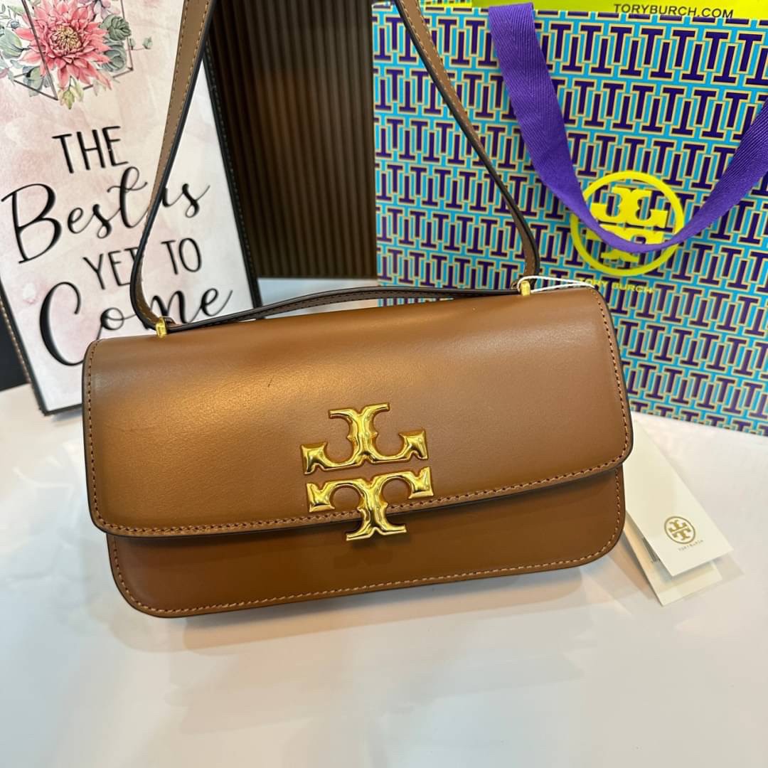 TORY BURCH ELEANOR SMALL LONG CONVERTIBLE SHOULDER กระเป๋าสะพายทรงยาว E/W Eleanor Convertible สูดหรู ดูแพง หนังแท้ เรียบสวยหรู โดดเด่นด้วยป้ายโลโก้สีทอง ลาย Double T อันเป็นเอกลักษณ์ ภายในช่องโล่งกว้างสามารถใส่โทรศัพท์ได้ทุกรุ่น สามารถใส่กระเป๋าสตางค์ใบยา