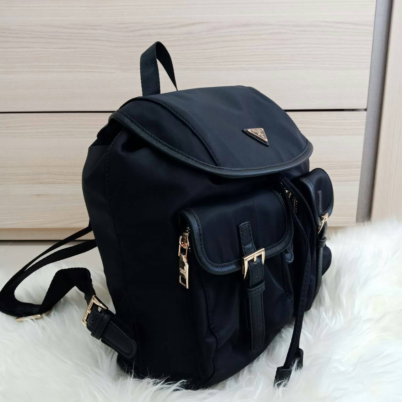 Prada nylon backpack with pocket กระเป๋าเป้ทรง signature จาก วัสดุ nylon เนื้อหนา ด้านหน้าประดับ logo brand, มีช่องใส่ของ 2 ช่อง กระเป๋าเปิดปิดด้วยกระดุมแม่เหล็ก และ drawstring ด้านในมีป้ายหนัง logo brand บุผ้าลายแบรนดอย่างดี สายสะพายปรับได้ freesize สายก