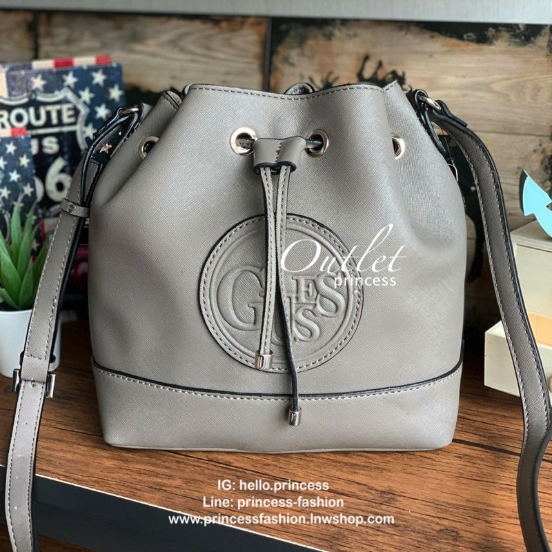 Guess Drawstring Bucket Bag กระเป๋าสะพายขนาดกลาง วัสดุลายหนังsaffiano ฐานกว้างตั้งอยู่ทรง มีซิกเนเจอร์ที่ด้านหน้าเป็นโลโก้ตัวนูน เปิดปิดแบบหูรูดและกระดุมแม่เหล็ก มีช่องใช้งานหลายข่อง สายสะพายปรับได้แบบเข็มขัด สวยแบบมีดีเทลเก๋ๆ สะพายเที่ยวระหว่างวันได้สบาย
