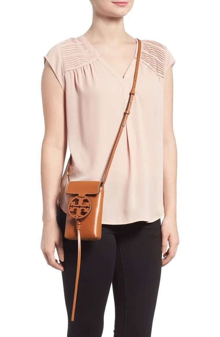 TORY BURCH MILLER METAL PHONE CROSSBODY อีกหนึ่งกระเป๋าใส่มือถือรุ่นฮิตที่เชื่อว่าหลาย ๆ คนต้องเคยเห็นผ่าน ๆ ตามาอย่างแน่นอน กับแบรนด์ Tory Burch ดีไซน์กระเป๋าทรงฝาพับแม่เหล็กใช้งานง่าย มาพร้อมดีเทล Logo สีเดียวกับเฉดสีของกระเป๋า แต่ยังมีความน่ารักด้วยทรง