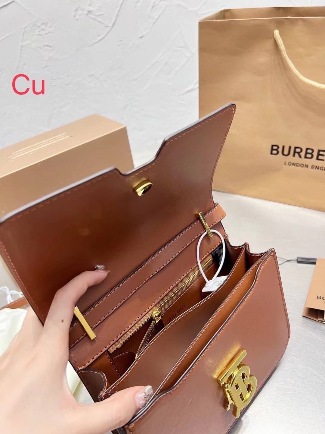 BURBERRY Leather Medium TB Bag / BURBERRY FRAGRANCES CROSSBODY BAG กระเป๋าสะพายหนังเรียบสวยอยู่ทรงดีไซน์ยอดนิยมประดับโลโก้แบรนด์ทองด้านหน้า เปิดปิดด้วยฝาปิดสัญลักษณ์ตัวB ภายในมีช่องแบ่งเป็นสัดส่วนมีช่องซิปหัวซิปแบรนด์