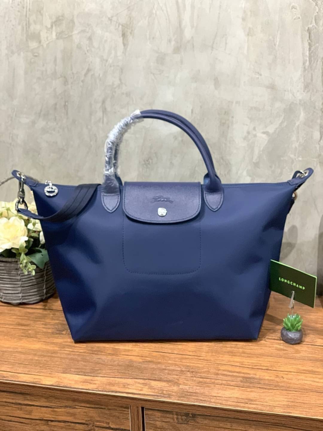 Longchamp Le Pliage Neo Size M มาพบกับกระเป๋ารุ่นยอดนิยม ที่สาวๆ ต้องมีไว้เก็บไว้สักใบ กระเป๋าโท้ทใบนี้ มาพร้อมกับสีที่มีสไตล์เรียบง่าย มีสายสะพายยาวช่วยให้คุณสามารถสะพายไหล่ได้อย่างสบาย ในขณะที่ที่ปิดแบบซิปช่วยให้คุณมั่นใจได้ว่าของด้านในมีความปลอดภัย Le 