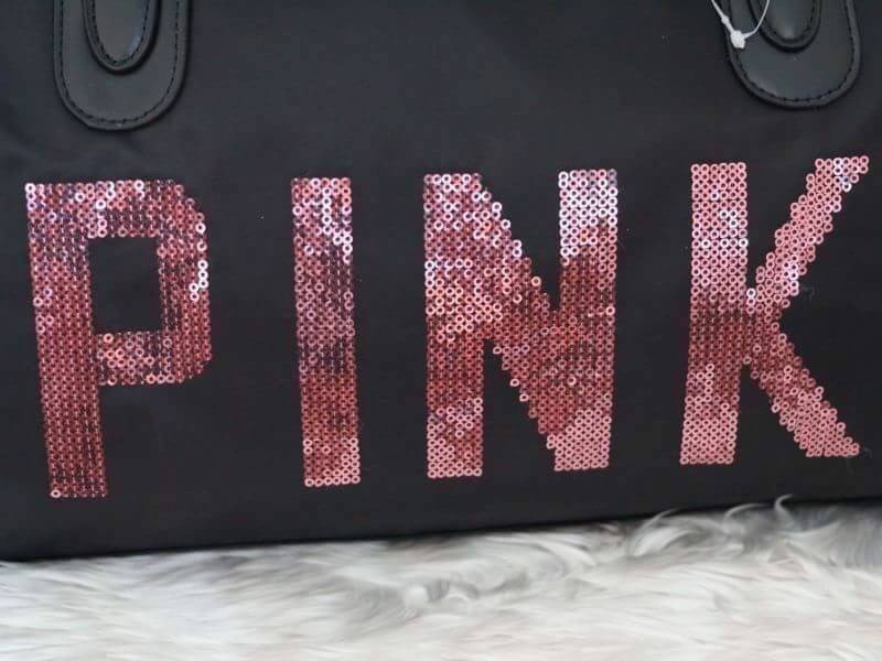 Victorias Secret PINK กระเป๋าสไตล์กระเป๋าเดินทาง หรือสะพายไปเล่นฟิตเนส ด้านหน้าจะมีตัวอักษร PINK เลื่อมสีชมพู เปิดปิดด้วยซิป ภายในมีช่องใหญ่ จุของได้เยอะ มีช่องใส่โทรศัพท์หรือของจุกจิก สามารถใส่เสื้อผ้าได้หลายชุด สายสะพายปรับระดับได้ และมีที่วางบ่าให้ด้วย
