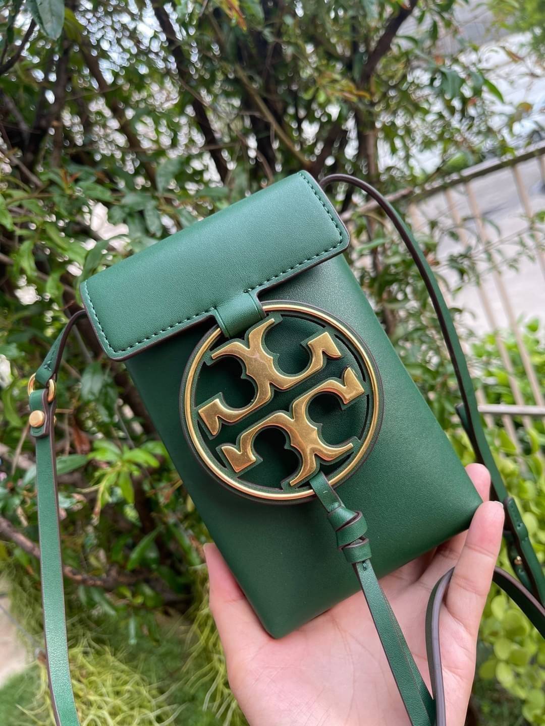 TORY BURCH MILLER METAL PHONE CROSSBODY อีกหนึ่งกระเป๋าใส่มือถือรุ่นฮิตที่เชื่อว่าหลาย ๆ คนต้องเคยเห็นผ่าน ๆ ตามาอย่างแน่นอน กับแบรนด์ Tory Burch ดีไซน์กระเป๋าทรงฝาพับแม่เหล็กใช้งานง่าย มาพร้อมดีเทล Logo แบรนด์โดดเด่นสีทองตัดกับหนังแกะสีดำ ดูหรูดูแพง! แต่