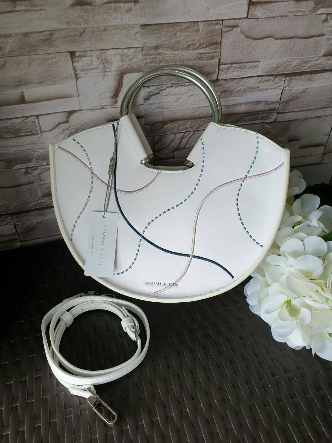 CHARLES & KEITH รุ่น U SHAPE TOP HANDLE BAG CK2-30780786_WHITE ราคาปกติช้อป ( ฿2,590.00 ) กระเป๋าทรงโค้งรูปตัว U วัสดุหนัง PU ลงแพทเทิร์นลวดลาย เส้นด้ายปักแต่งสีสัน บนตัวกระเป๋า เพิ่มความสวยสะดุดตา รับประกันความเก๋!! จะทำให้คุณโดดเด่นไม่เหมือนใคร หูกระเป๋