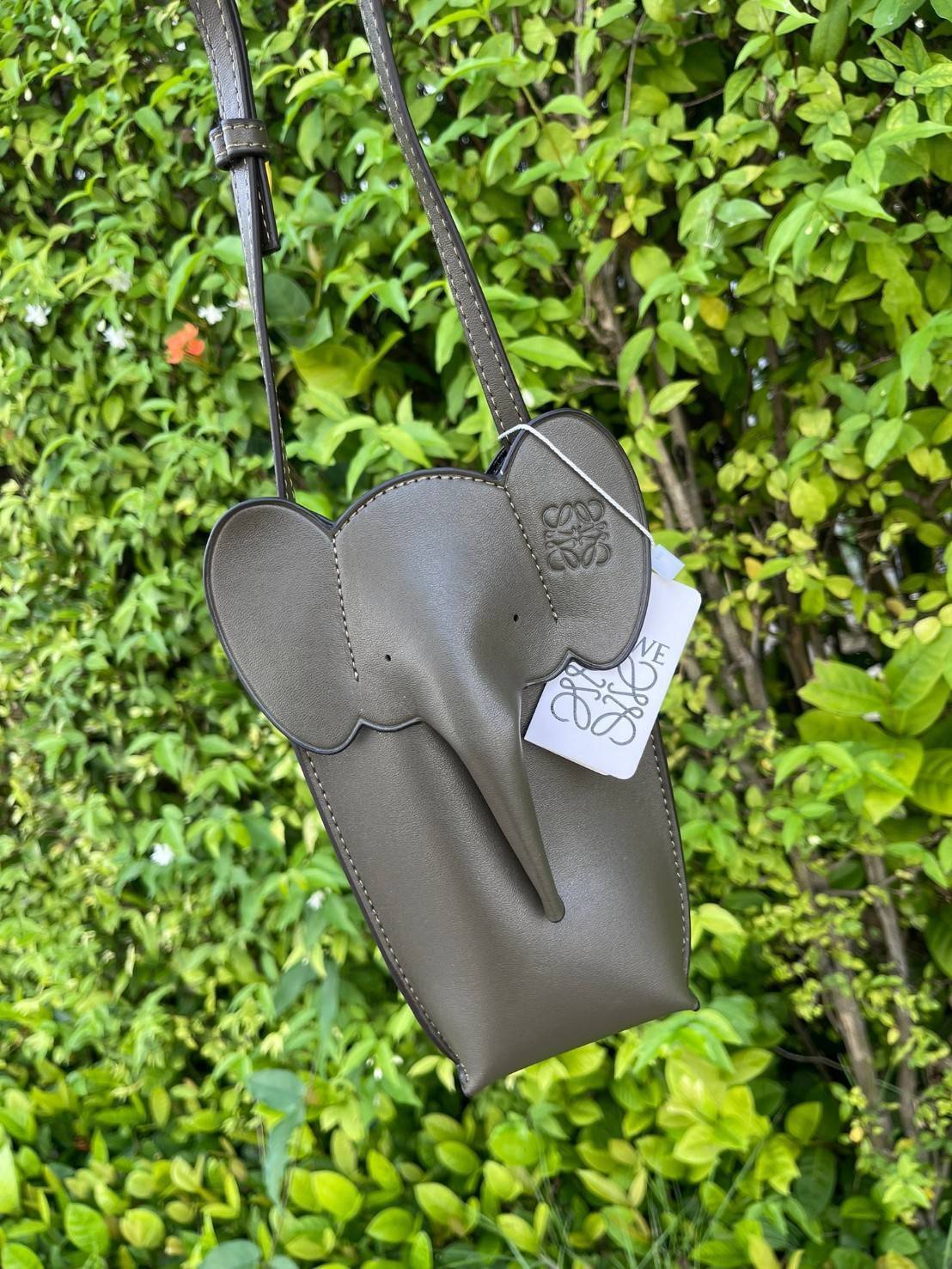 Loewe Leather Elephant Phone Holder แบรนด์หรูจากประเทศสเปนอย่าง โลเอเว่ (LOEWE) หลายๆคนคงนึกถึงกระเป๋ารูปทรงช้างขนาดเล็ก ที่เป็นเหมือนหนึ่งในซิกเนเจอร์ของแบรนด์ มีทั้งแบบสะพายข้าง แบบถือ รวมไปถึงในแบบเครื่องหนังชิ้นเล็กอย่างกระเป๋าใส่มือถือรุ่นนี้ ผลิตจาก