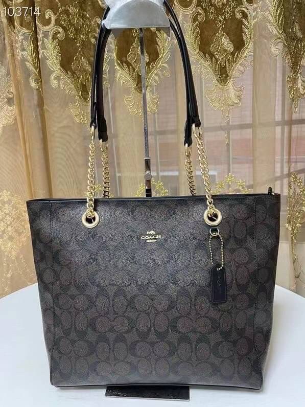 COACH Tote in Signature Canvas Bag กระเป๋าสะพายทรงช้อปปิ้ง สายกระเป๋าเป็นหนังสลับโซ่ทองสวยงาม เพิ่มความหรูหรา ภายในโล่งกว้างใส่ของได้เยอะมาก วัสดุ Canvas เคลือบลายซิกเนเจอร์และหนัง พร้อมซิปกลางเก็บของได้มิดชิดเลยค่ะ มี 3 สี น้ำตาล ดำ ขาว