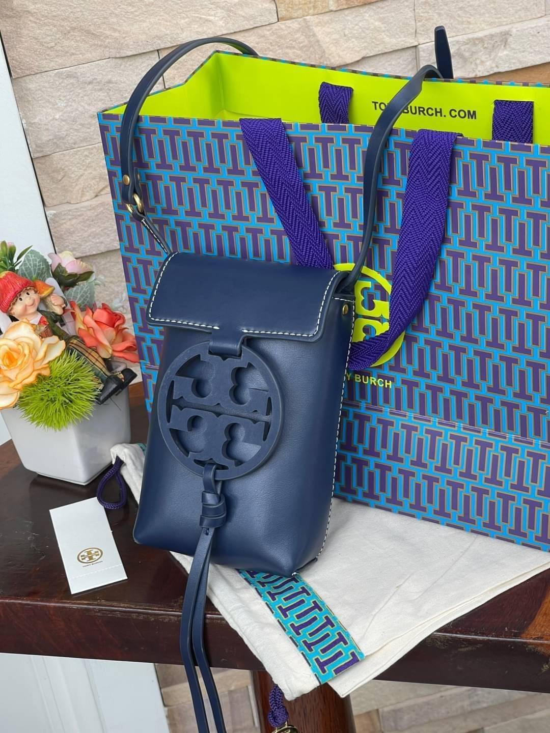 TORY BURCH MILLER METAL PHONE CROSSBODY อีกหนึ่งกระเป๋าใส่มือถือรุ่นฮิตที่เชื่อว่าหลาย ๆ คนต้องเคยเห็นผ่าน ๆ ตามาอย่างแน่นอน กับแบรนด์ Tory Burch ดีไซน์กระเป๋าทรงฝาพับแม่เหล็กใช้งานง่าย มาพร้อมดีเทล Logo สีเดียวกับเฉดสีของกระเป๋า แต่ยังมีความน่ารักด้วยทรง