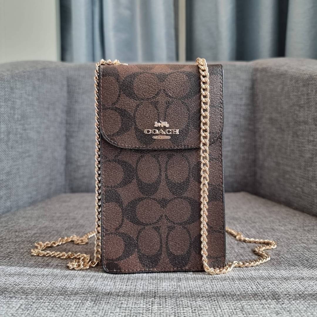 COACH NORTH/SOUTH PHONE CROSSBODY IN SIGNATURE CANVAS F55636 F39955 สุดคลาสสิคกับกระเป๋าสะพายเอนกประสงค์ Case phone ใส่โทรศัพท์มือถือได้ทุกรุ่น ดีไซน์ลายเอกลักษณ์ วัสดุหนังแคนวาสเคลือบลาย ฝาและภายในเป็นหนังสังเคราะห์เรียบ เปิด-ปิดด้วยกระดุม สายสะพายยาวประ