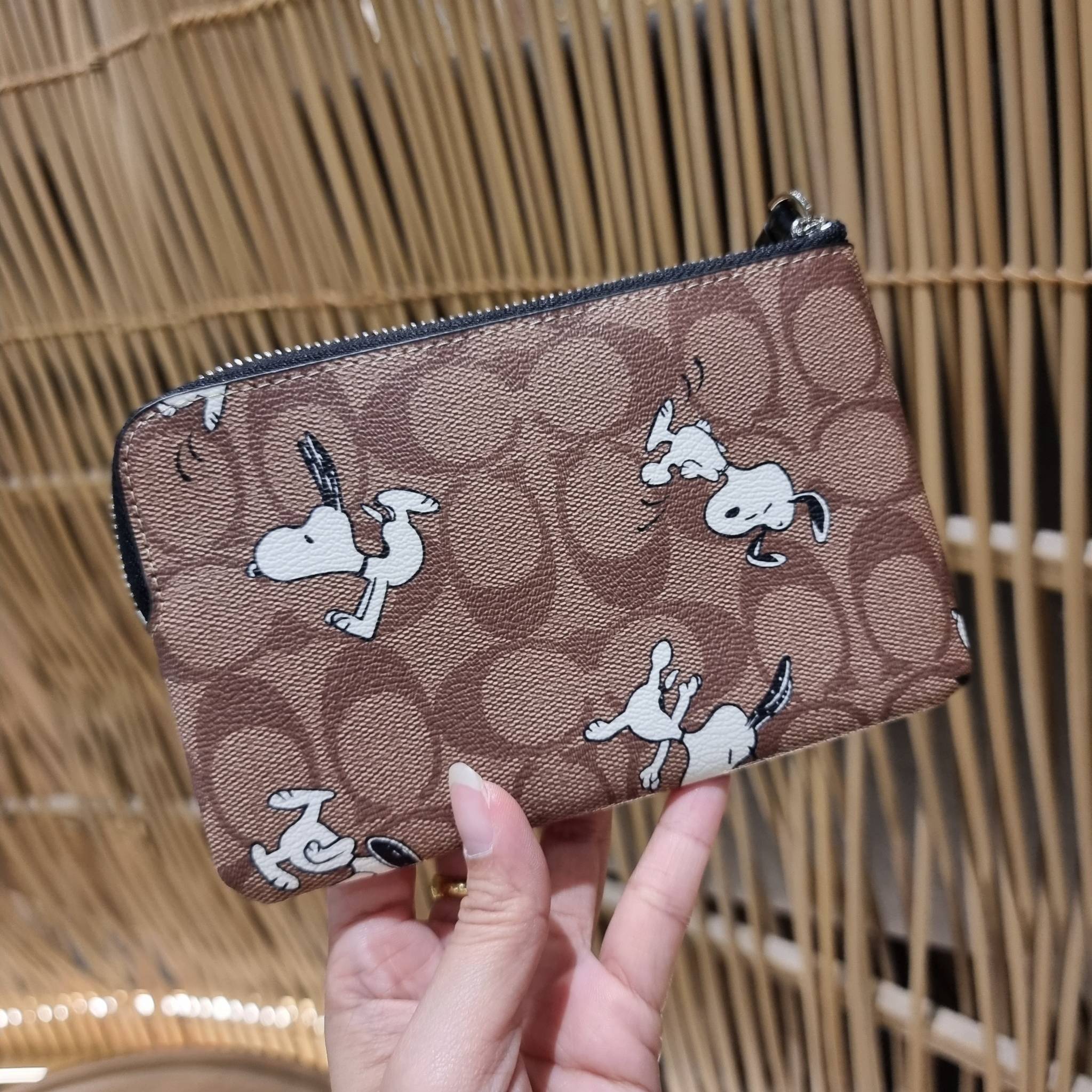 COACH C4589 COACH x PEANUTS CORNER ZIP WRISTLET IN SIGNATURE CANVAS WITH SNOOPY PRINT เหล่าผองเพื่อนและสนูปพีมาแล้วจ้า คอลเลคชั่นสุดน่ารักที่ฮอตไม่มีตก กระเป๋าคล้องมือ ขนาดเหมาะพกพากำลังเหมาะ วัสดุหนังแคนวาสเคลือบลาย ภายในเป็นช่องโล่ง ใส่ธนบัตร หรือใส่บัต