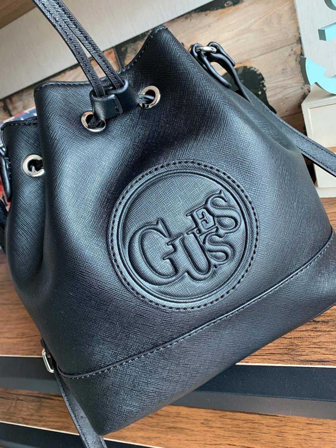 Guess Drawstring Bucket Bag กระเป๋าสะพายขนาดกลาง วัสดุลายหนังsaffiano ฐานกว้างตั้งอยู่ทรง มีซิกเนเจอร์ที่ด้านหน้าเป็นโลโก้ตัวนูน เปิดปิดแบบหูรูดและกระดุมแม่เหล็ก มีช่องใช้งานหลายข่อง สายสะพายปรับได้แบบเข็มขัด สวยแบบมีดีเทลเก๋ๆ สะพายเที่ยวระหว่างวันได้สบาย