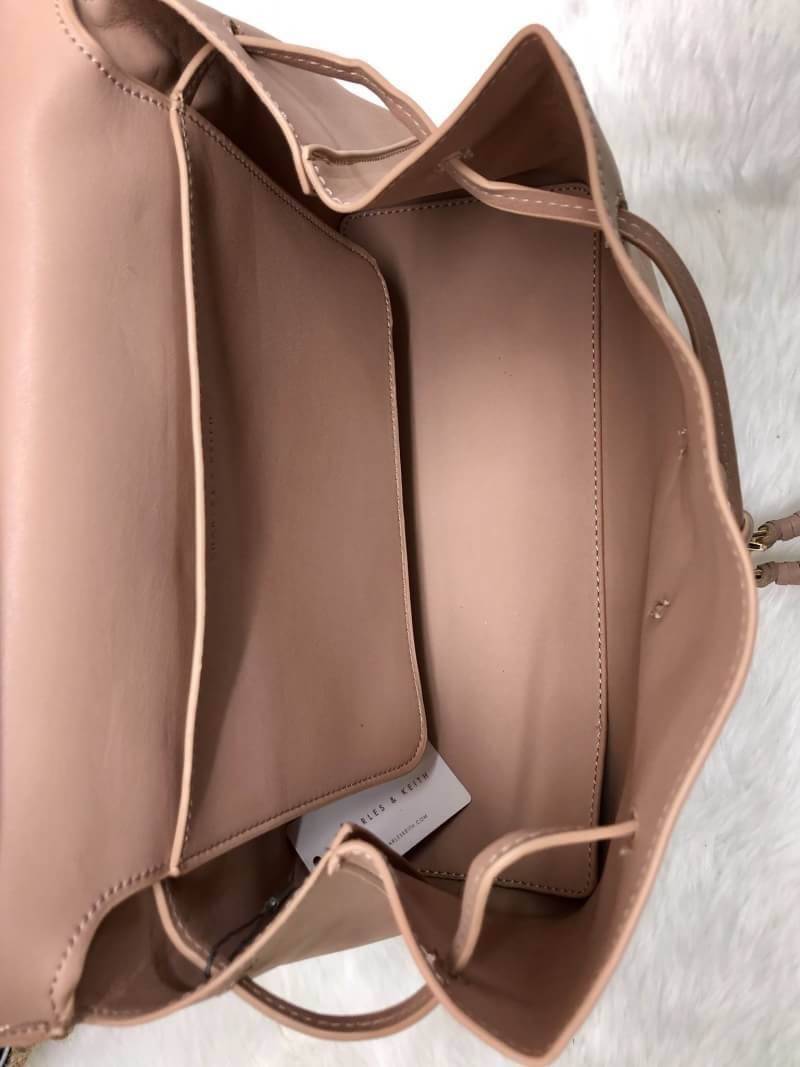 CHARLES & KEITH TASSEL DETAIL SLING BAG กระเป๋าสะพายทรงสวย ที่ฝาพับด้านหน้าแต่งหนังตัดกับหนังกลับสวยงาม สะพายได้ทั้งแบบเป้ และสะพายข้างก็เก๋ไปอีกแบบ มีโซ่เหล็กห่วงห้อยตุ้งติ้งน่ารัก จุของได้เยอะ พร้อมปั๊มโลโก้แบรนด์สีทองเด่น ภายในมีช่องแบ่งใหญ่ใส่ iPhone 