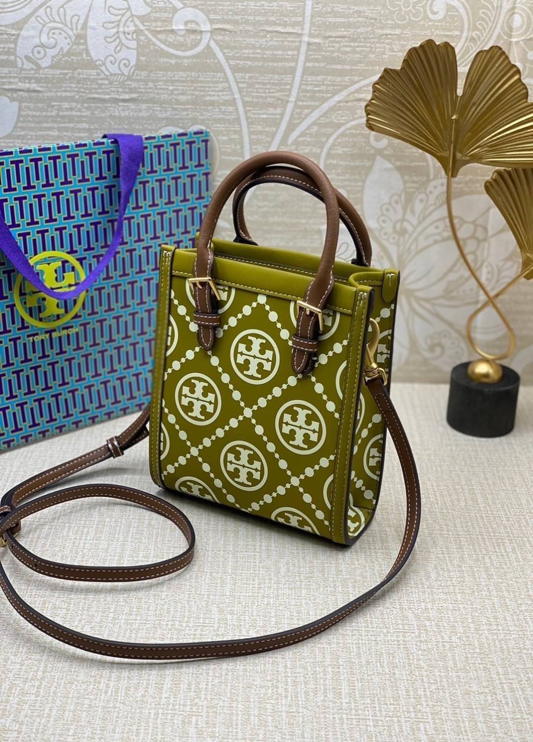 TORY BURCH T MONOGRAM EMBOSSED MINI TOTE สุดหรูกับกระเป๋าสะพายทรงโท้ท ไซส์มินิ ที่สร้างความหรูหราให้ตัวกระเป๋าด้วยดีเทลลายนูน แต่งแต้มลวดลายเอกลักษณ์ สีลูกคุณมากๆ!! วัสดุหนังแท้ ผิวสัมผัสดี ปากกระเป๋ามีแถบแม่เหล็กกันของหล่นได้ ภายในโล่ง ใส่ของจำเป็นได้ โท