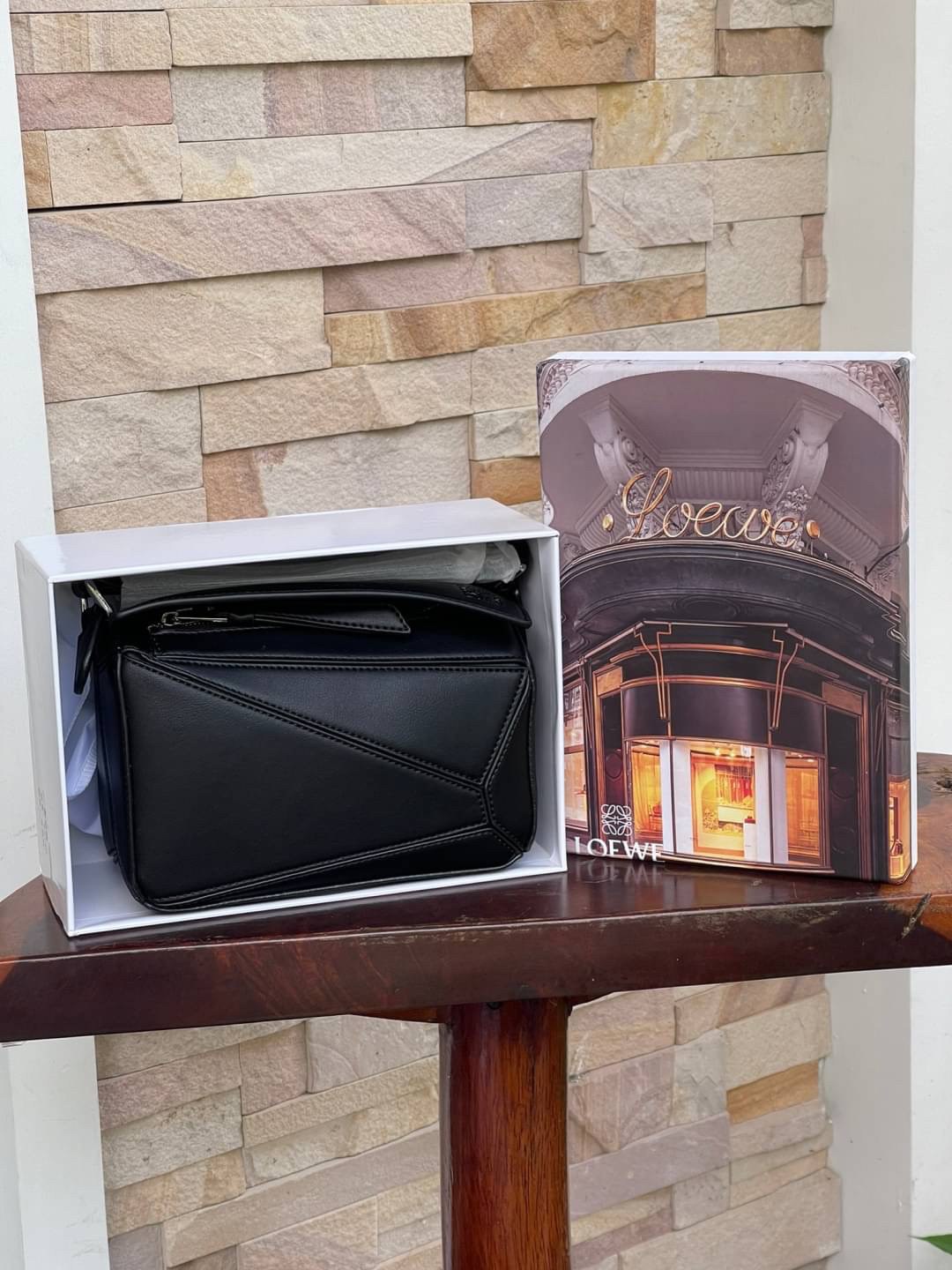 Loewe Nano Puzzle bag in classic โลเอเว่ (LOEWE) อีกหนึ่งกระเป๋าแบรนด์ดังจากสเปน ภายใต้คอลเลคชั่นใหม่อันร่วมสมัยของแบรนด์ มีความเป็นคลาสสิคและโมเดิร์นทันสมัย กระเป๋าที่มาในรูปแบบสี่เหลี่ยมผืนผ้า ที่สามารถใช้งานได้ทั้งแบบหูหิ้ว และแบบ Crossbody ด้านในมีช่อ