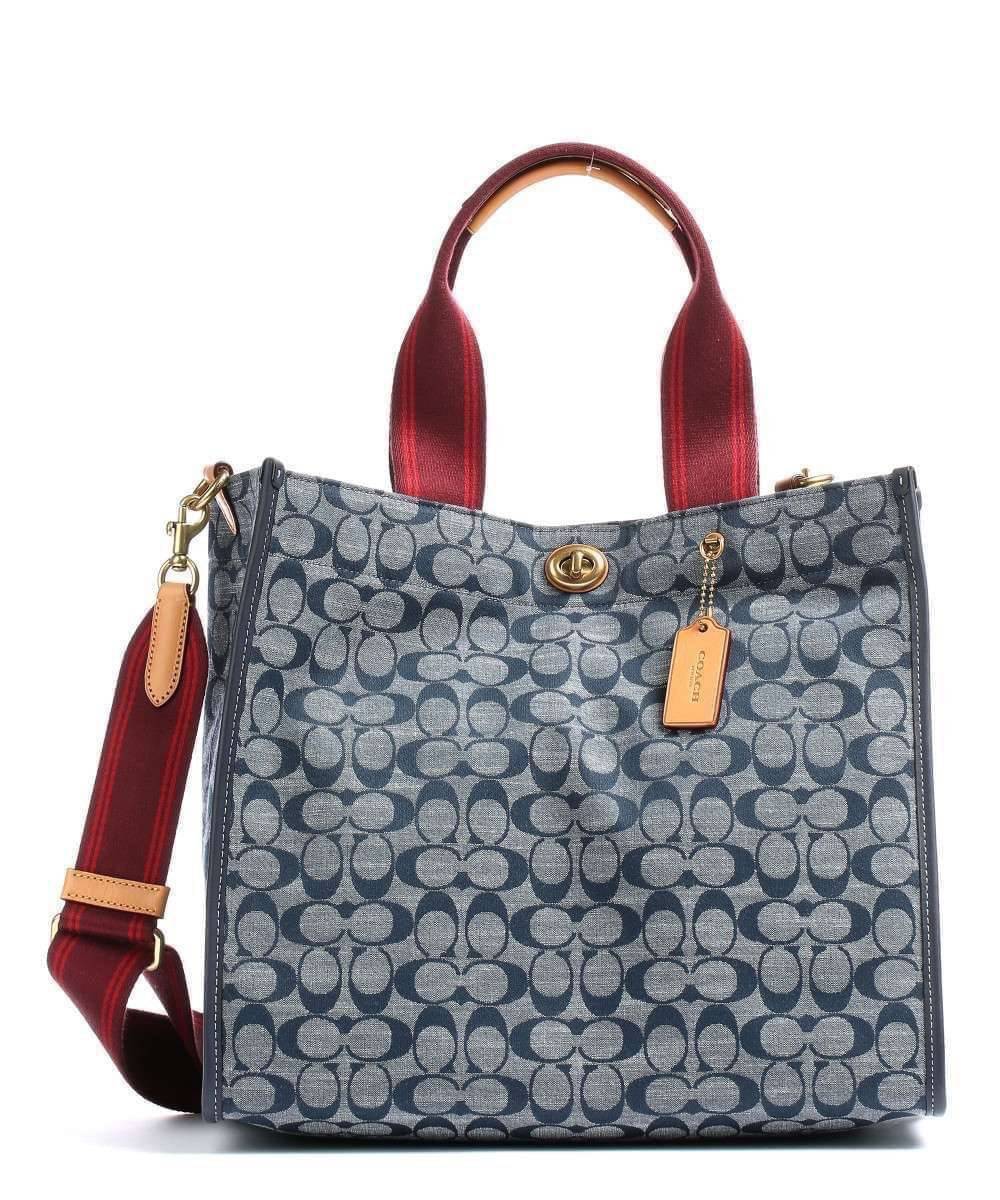 COACH Tote 34 In Signature Chambray หากคุณกำลังมองหากระเป๋าที่มีดีไซน์แปลกตา ไม่ค่อยเหมือนที่พบเห็นทั่วไป ต้องเป็นรุ่นนี้เลยค่ะ นอกจากจะผลิตจากผ้าแชมเบรย์ซึ่งมีน้ำหนักเบาแล้ว ยังให้สีสันคล้ายกับสียีนส์ สายสะพายและหูหิ้วสไตล์สปอร์ต ที่สำคัญยังมีหมุดปิดกระเ