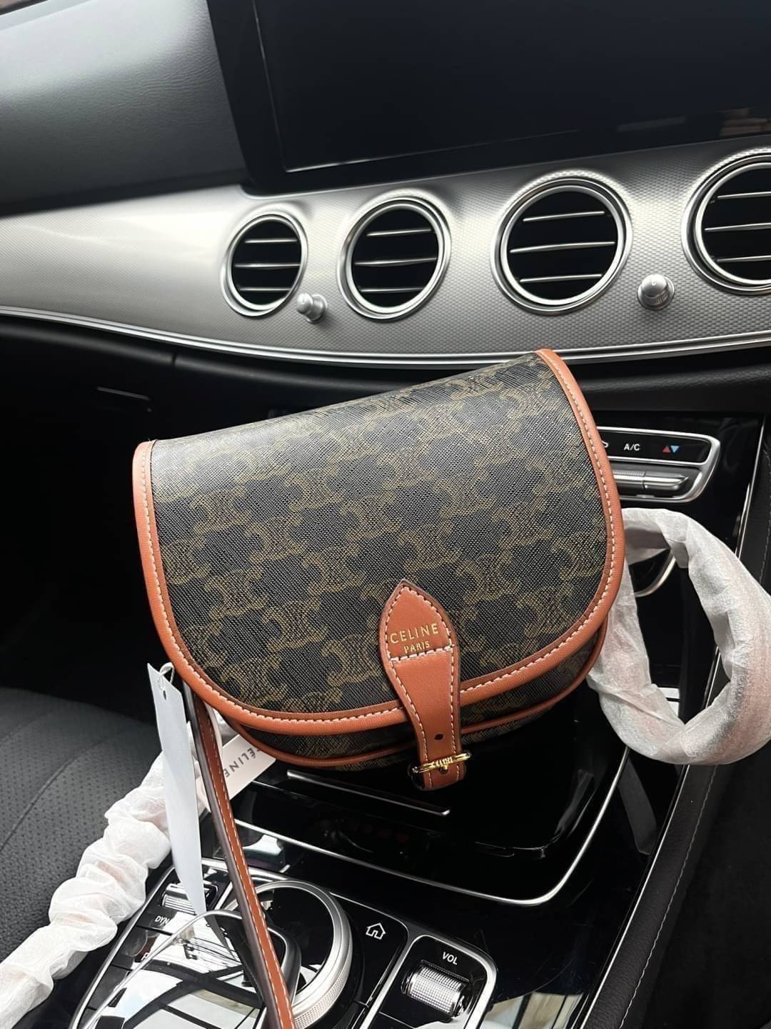 CELINE MEDIUM FOLCO BAG IN TRIOMPHE CANVAS หากใครที่กำลังมองหากระเป๋าสะพายข้าง ขนาดกะทัดรัด และเรียบหรู ต้องใบนี้เลยค่ะ เป็นกระเป๋าเปิดปิดแบบแบบฝาผับที่มีรูปทรงโค้งและที่ล็อกรูปทรงคล้ายเข็มขัด อีกทั้งยังสะท้อนความสวยสไตล์สาวปารีสได้อีกด้วย ด้านในของรุ่นนี