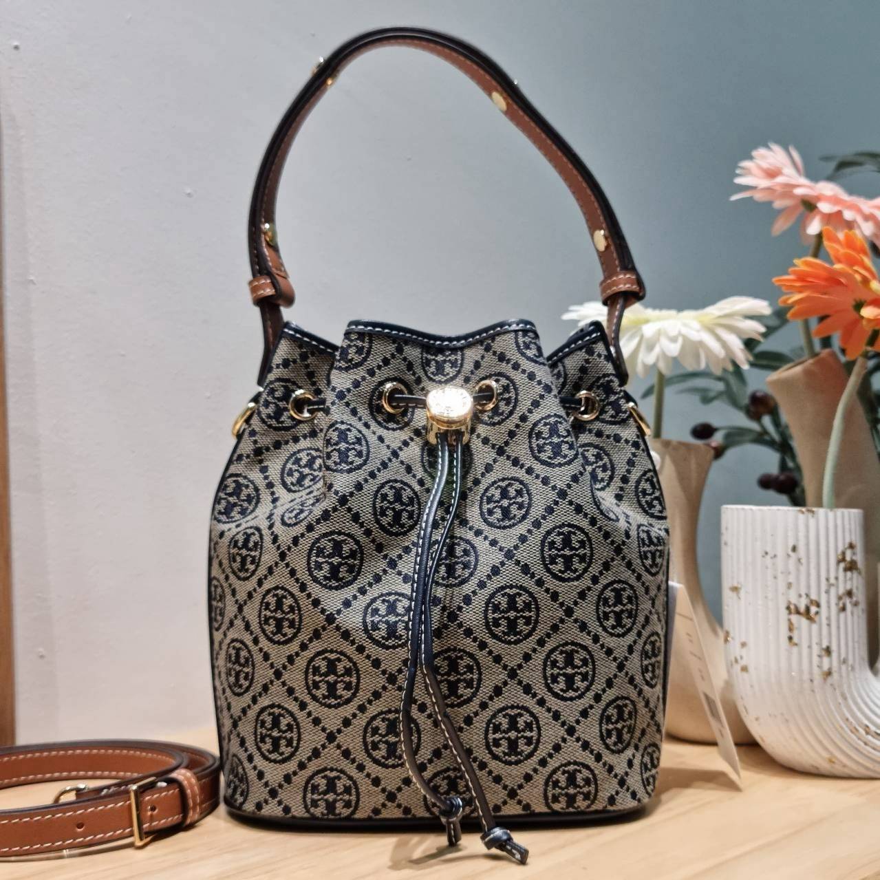 TOP ORI หนังแท้ | เกรดดีสุด TORY BURCH T MONOGRAM BUCKET BAG (ดีไซน์ใหม่) ใหม่ล่าสุดได้สวยก่อนใคร กับกระเป๋าบัคเก็ตยอดฮิต ที่มาในดีไซน์ใหม่ สายคล้องในตัวสามารถปรับได้ รูปทรงและลวดลายสวยชัดคลาสสิค