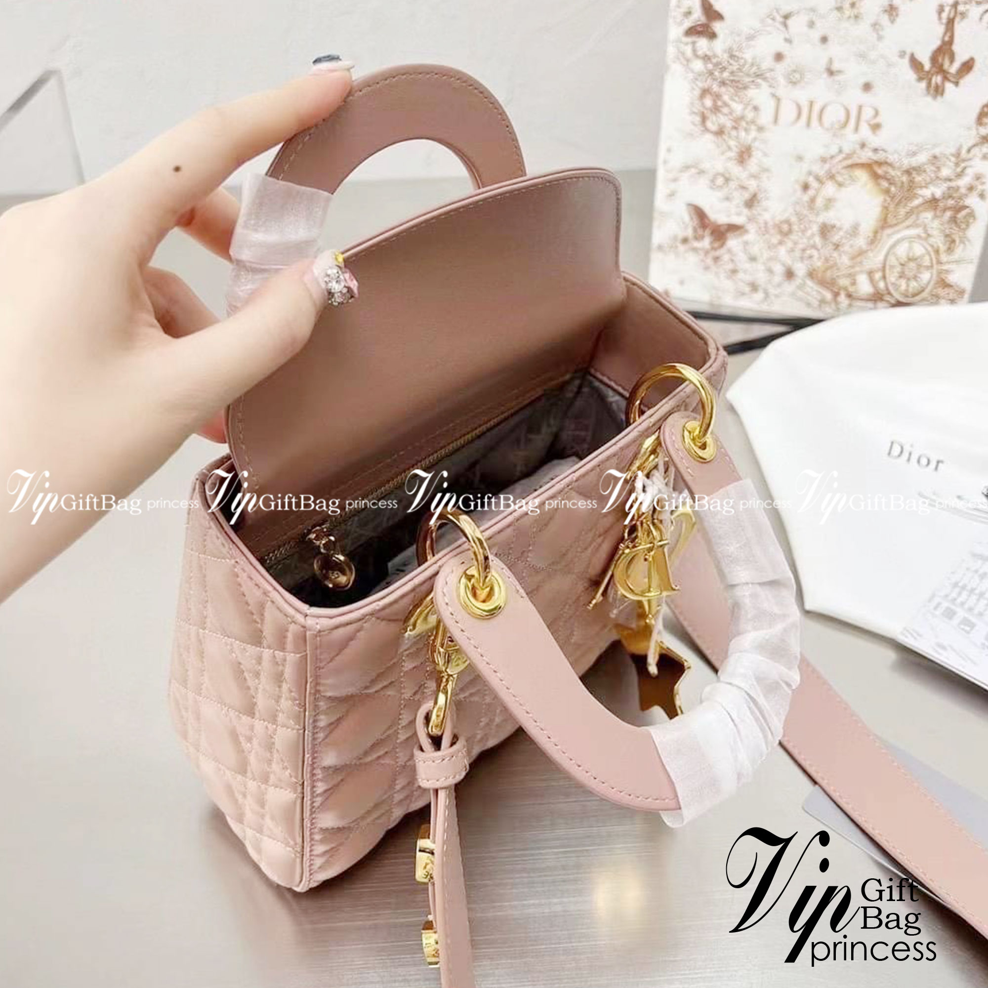 DIOR Lady / Small Lady Dior Bag Cannage Lambskin กระเป๋าสุดไอคอนิก รูปทรงสีเหลียม ขนาดกระทัดรัด ตั้งอยู่ทรง ฐานกระเป๋าแข็งแรง มีหมุดรองฐาน ดีไซน์เอกลักษณ์เฉพาะตัว ด้านหน้าตกแต่งด้วยตัวอักษร D.I.R ห้อยเป็นพวงกุญแจ จะถือหรือสะพายไหล่ก็ดูดีมากๆ ค่ะ