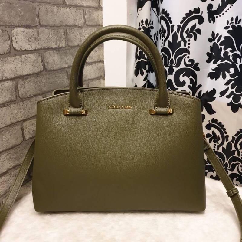 CHARLES & KEITH CLASSIC TOP HANDLE BAG กระเป๋าถือหรือสะพายใบใหญ่ ทรงแข็ง หนัง pu สวย ดีไซน์เรียบหรู ดูดี ด้านหน้าป้ายโลโก้แบบนูน ด้านหลังมีซ่องซิป 1 ช่อง เปิด-ปิดแบบกระดุมแม่เหล็ก ภายในมี 2 ช่องใหญ่ คั่นกลางด้วยช่องซิป มีหมุดรองรองฐานสี่มุม มาพร้อมสายสะพา