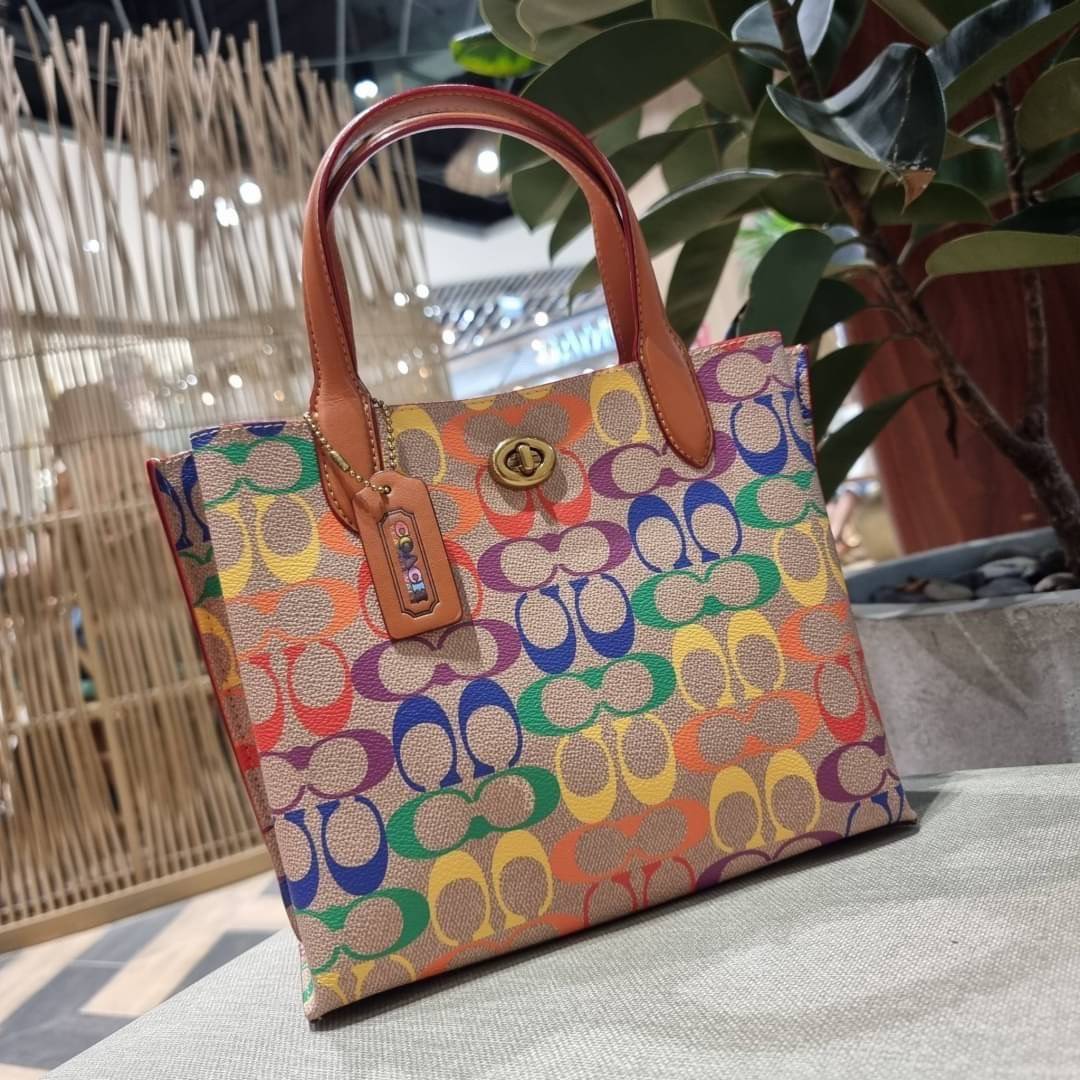 COACH CA102 WILLOW TOTE 24 IN RAINBOW SIGNATURE CANVAS ไปให้สุดกับความเลิศของลวดลายสายรุ้ง ที่แต่งแต้มลงบนกระเป๋าทรงโท้ท ไซส์กำลังสวย พกพาได้สะดวก มีตัวบิดล็อคที่ปากกระเป๋าด้านหนึ่ง และกระดุมแม่เหล็กอีกด้านหนึ่ง ภายในโล่งกว้าง เก็บของได้เป็นสัดส่วนไปเลย ม