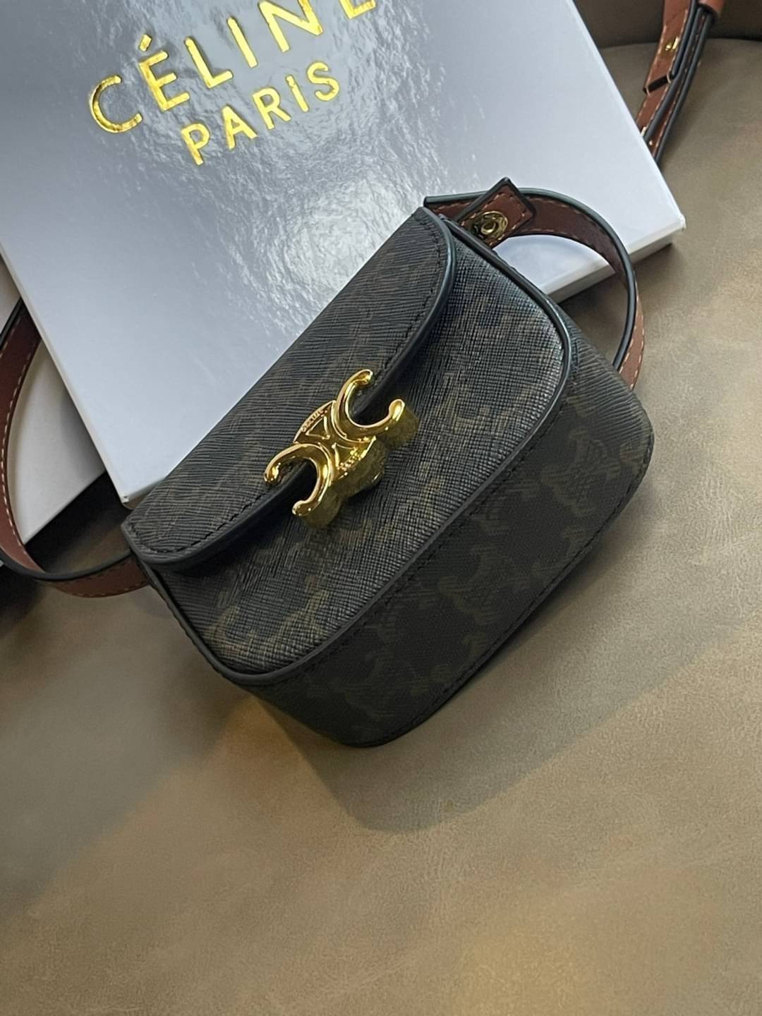 CELINE MINI TRIOMPHE IN TRIOMPHE CANVAS กระเป๋ามินิทรงชิค ดีไซน์รูปกล่องสุดแสนมินิมอล สามารถสะพายแบบ Crossbody และยังเป็น Belt Bagได้อีกด้วย วัสดุแคนวาสลาย Triomphe แบบไม่มีตกยุค ด้านหน้าโดดเด่นด้วยโลโก้สีทอง เป็นอีกหนึ่งตัวเลือกให้คุณเลือกสะพายในชีวิตประ