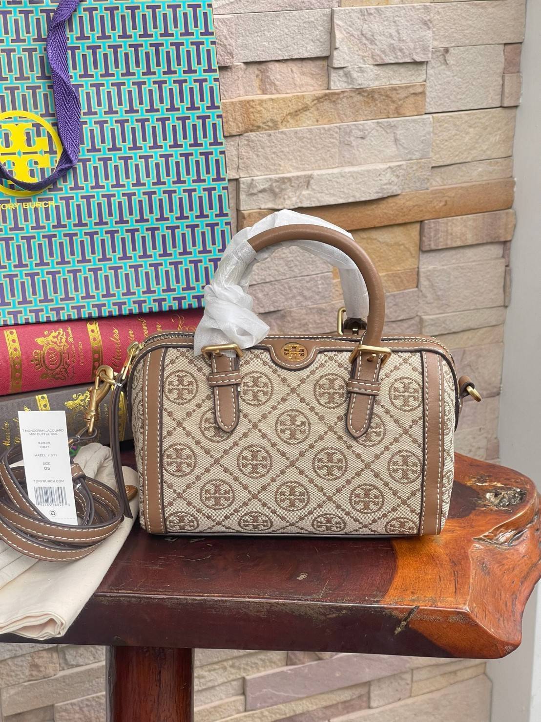 small: Tory burch T Monograme Jacquaed Mini Duffle Bag เป็นทรงกระเป๋าที่มีความฮอตฮิตตลอดกาล ด้วยรูปทรงคลาสสิคและเหมาะใช้งานเข้ากับทุกสถานการณ์ ไม่ว่าจะเป็นกระเป๋าสะพายไหล่ เพิ่มความคล่องตัวและเข้าได้กับทุกลุค ไม่ว่าจะเป็นวันสบายๆ หรือวันที่ต้องออกไปทำกิจก