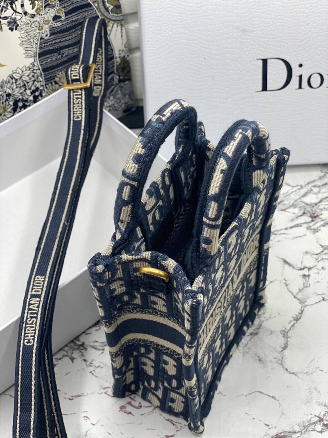 ORI 】Mini Dior Book Tote Phone Bag Blue Dior Oblique Embroidery พร้อมส่งที่ไทย ภาพสินค้าถ่ายจากงานขายจริง ใช้งานต่างประเทศได้ กระเป๋าใบมินิจะใส่โทรศัพท์ได้เช่นเดียวกับของใช้จำเป็นเล็กๆ น้อยๆ ในแต่ละวัน มาพร้อมสายสะพายไหล่แบบปักที่ปรับได้และถอดออกได้ อุปกร